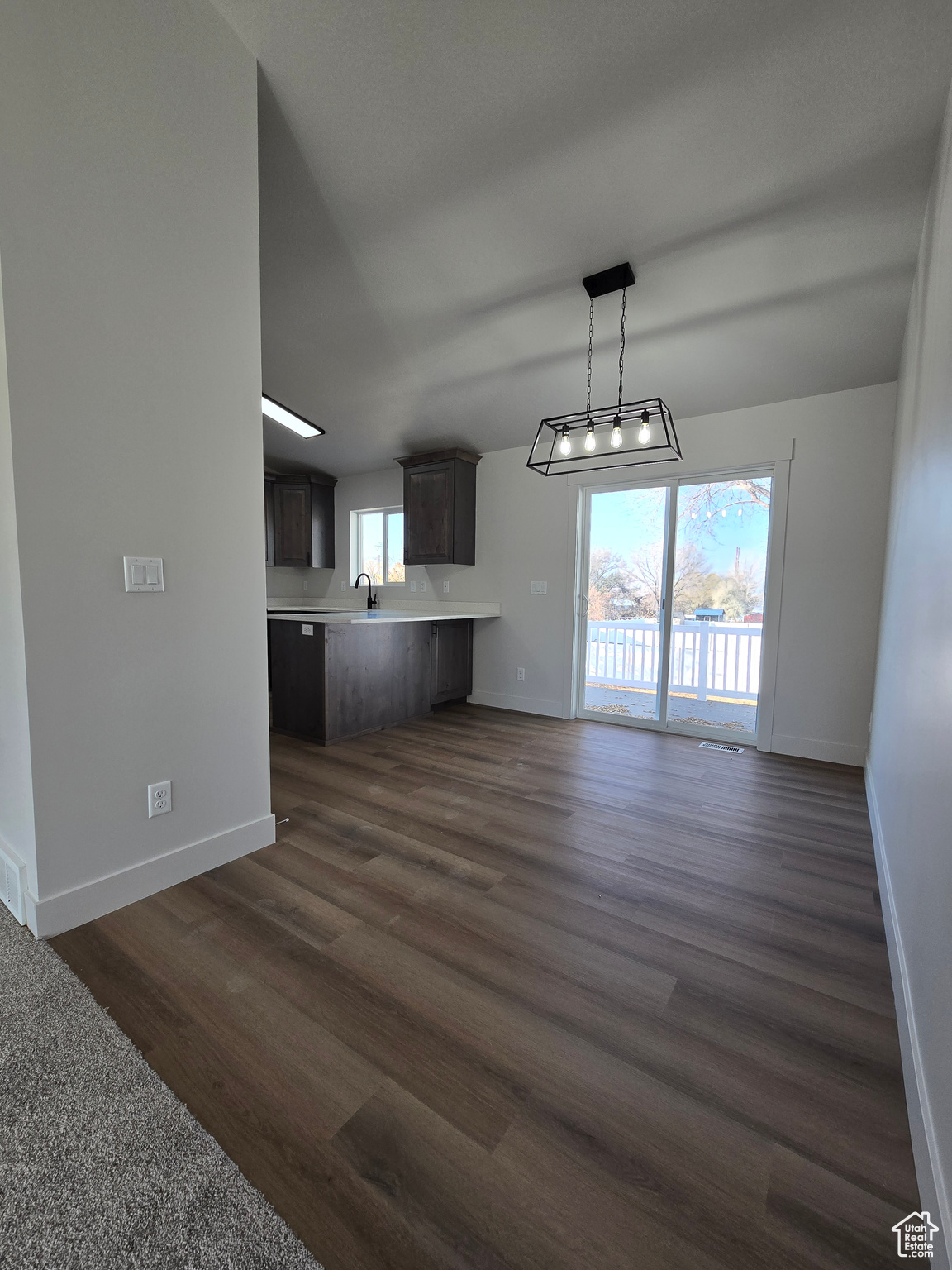 Unfurnished living room with sink and dark hardwood / wood-style floors