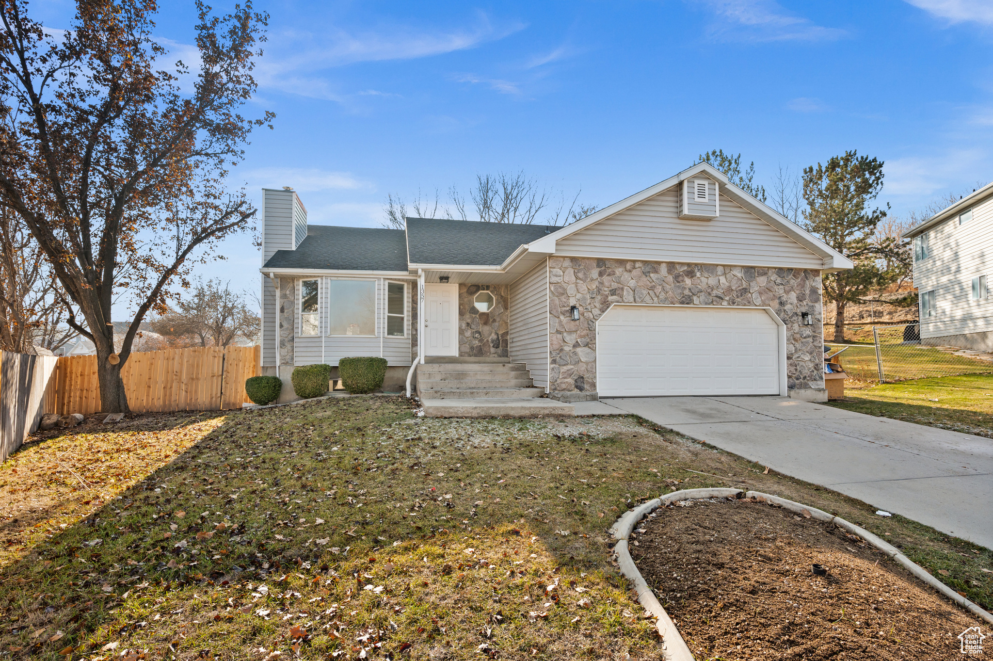 Single story home with a garage and a front yard