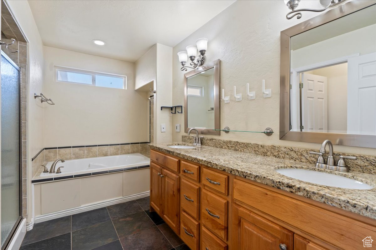 Bathroom featuring vanity and independent shower and bath