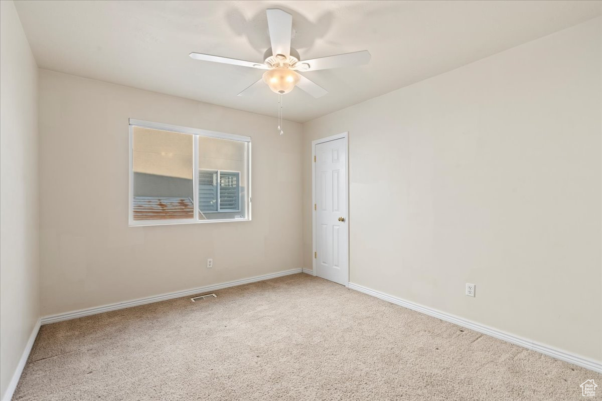 Unfurnished room with ceiling fan and carpet floors