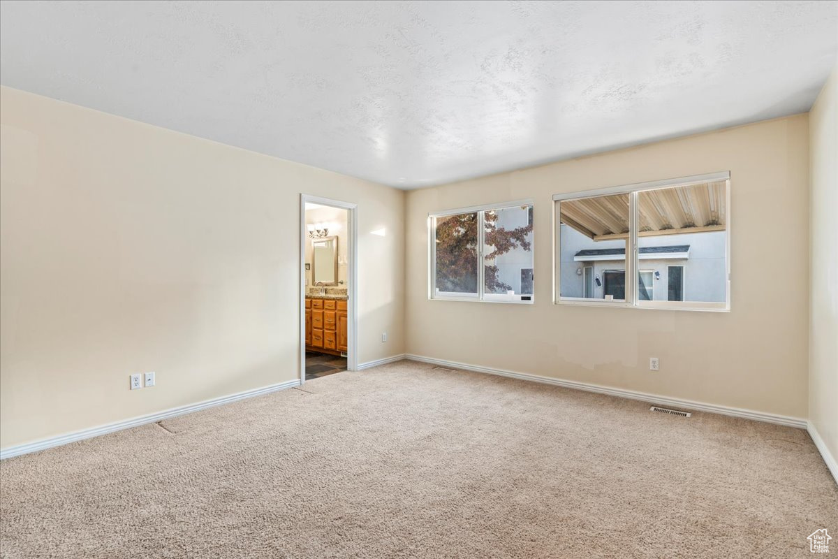 Carpeted spare room featuring a textured ceiling