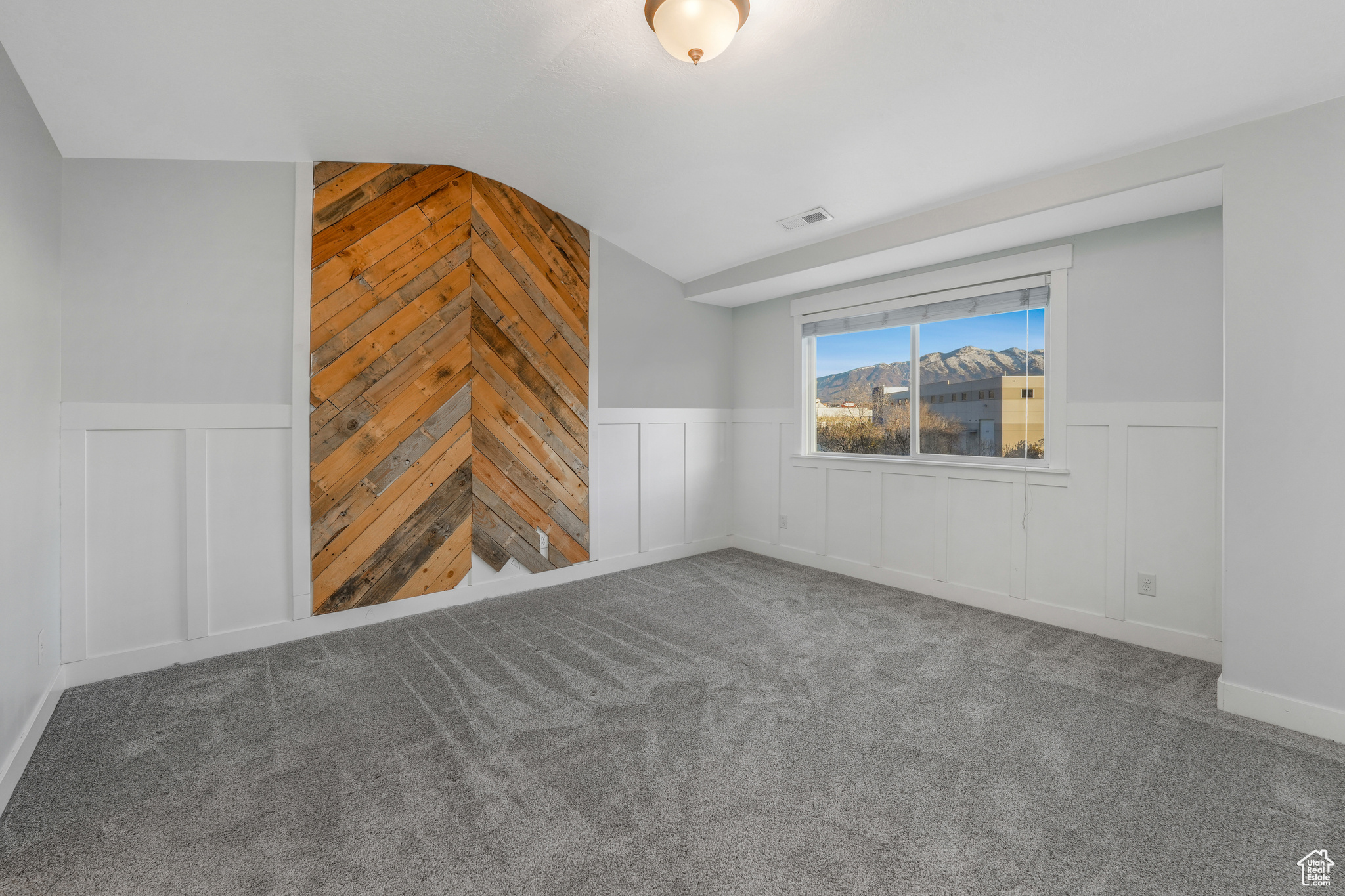 Unfurnished living room featuring lofted ceiling, carpet floors, and wooden walls