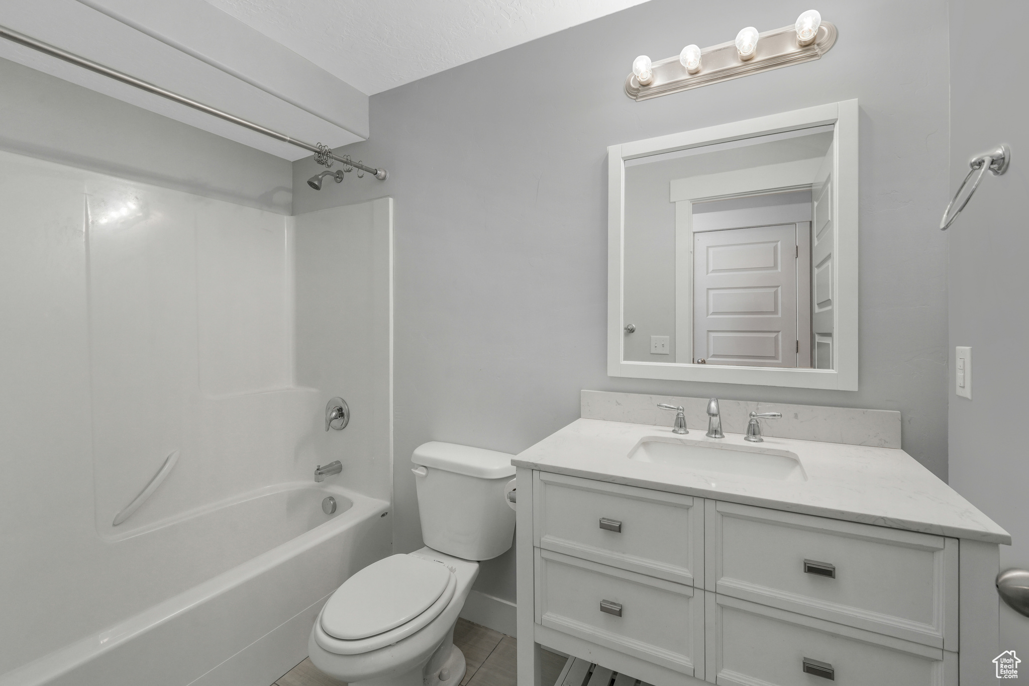 Full bathroom with vanity,  shower combination, toilet, and tile patterned flooring