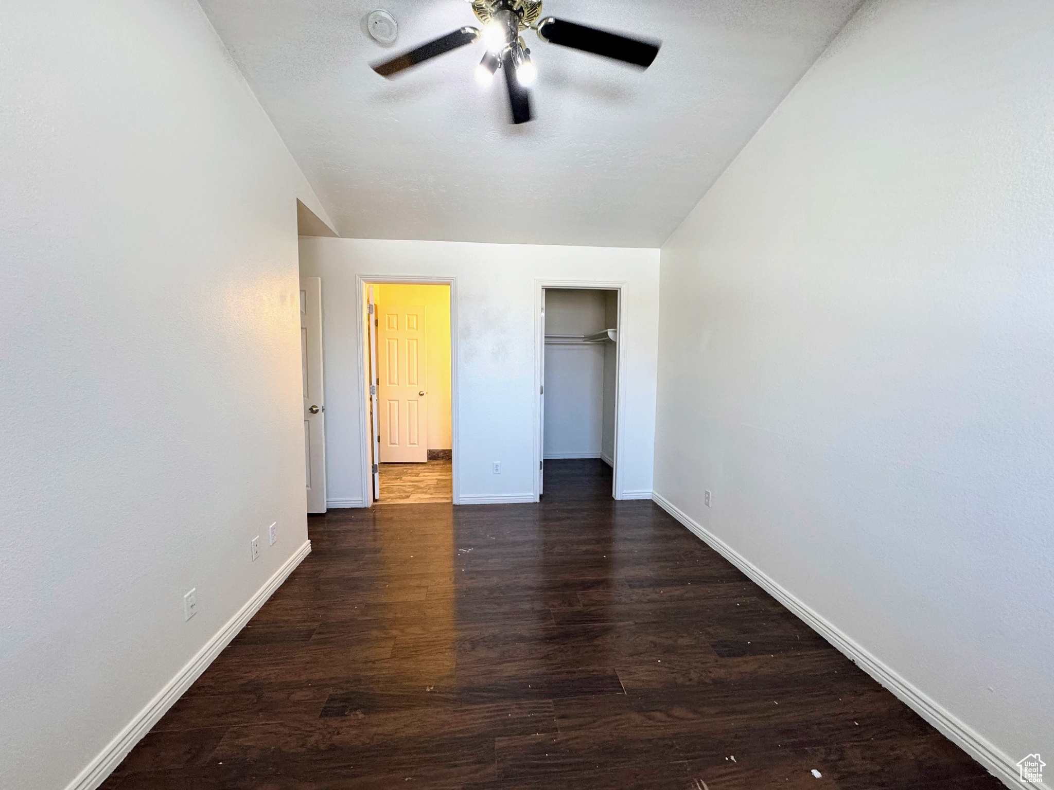 Unfurnished bedroom featuring dark hardwood / wood-style floors and ceiling fan