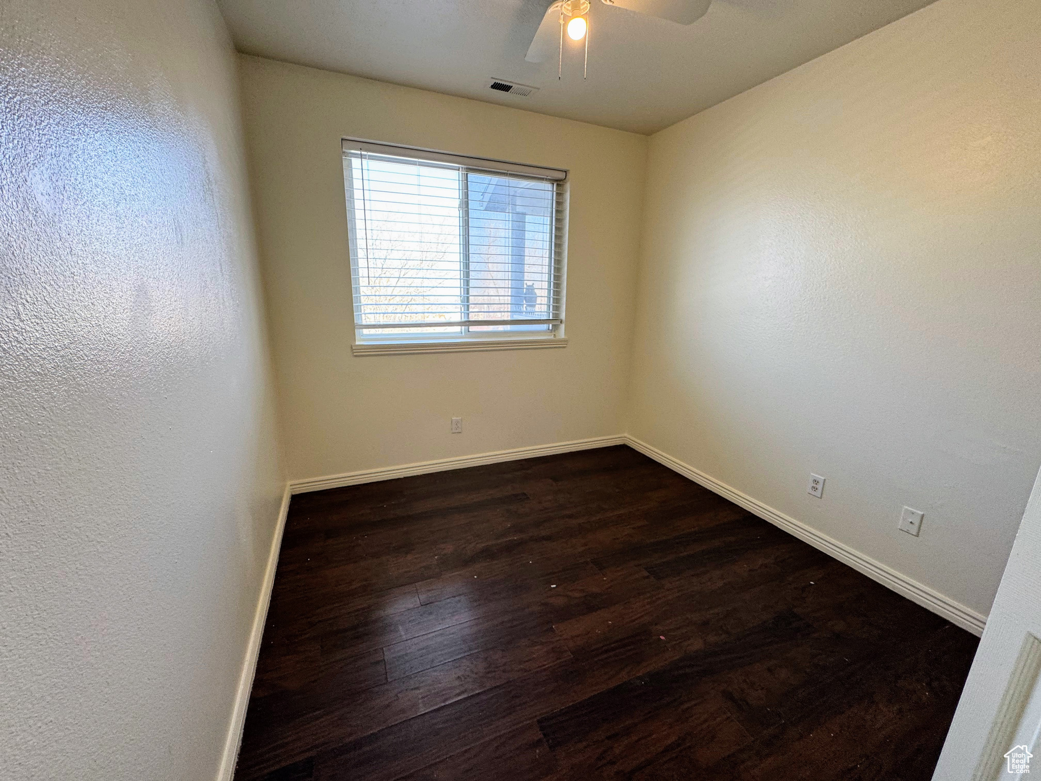 Unfurnished room featuring ceiling fan and dark hardwood / wood-style flooring