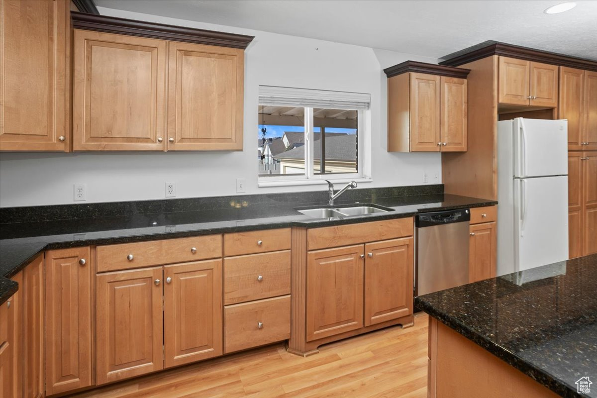 Kitchen with granite countertops, stainless steel appliances, light hardwood / wood-style floors, and a kitchen island