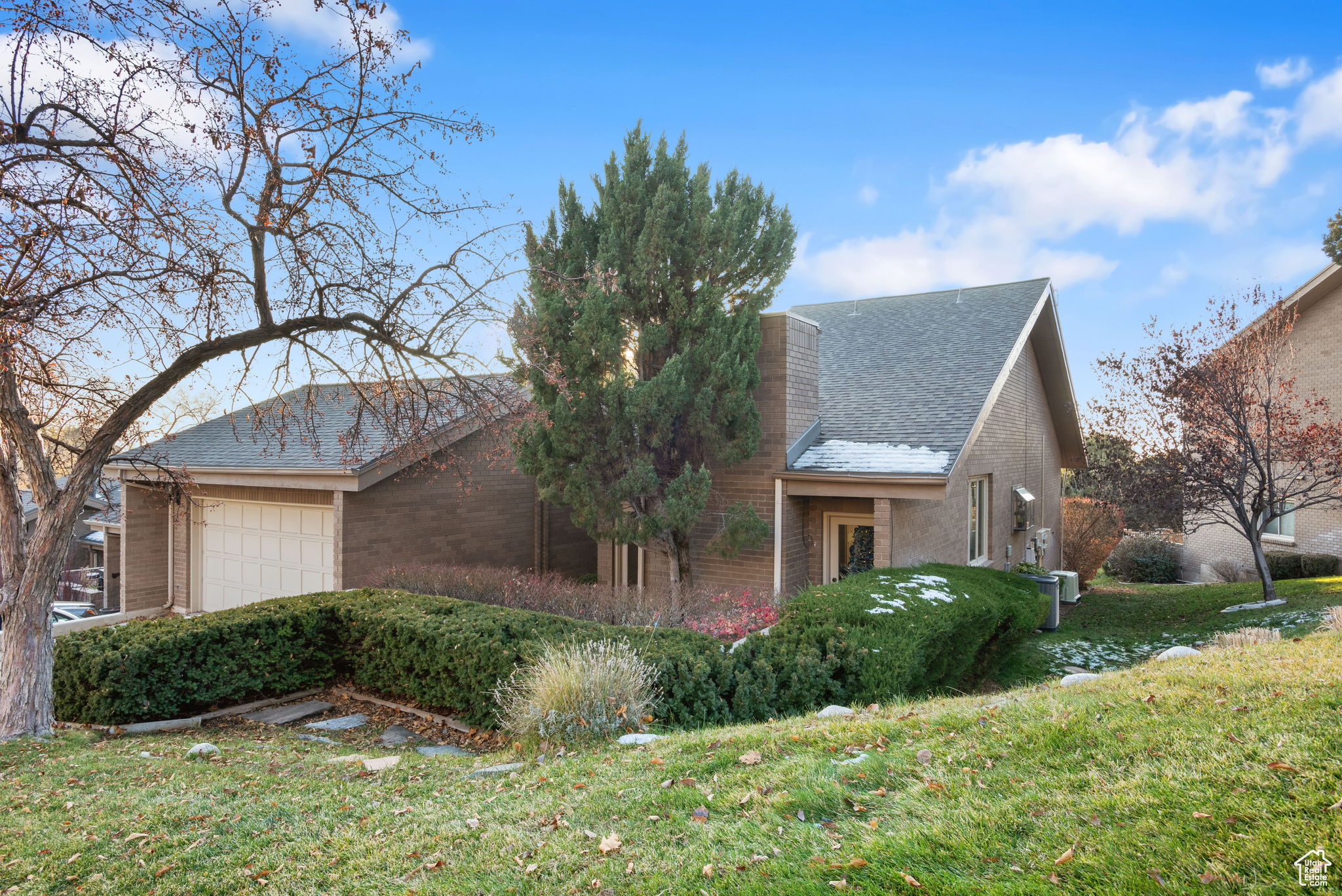 View of property exterior with a garage and a lawn