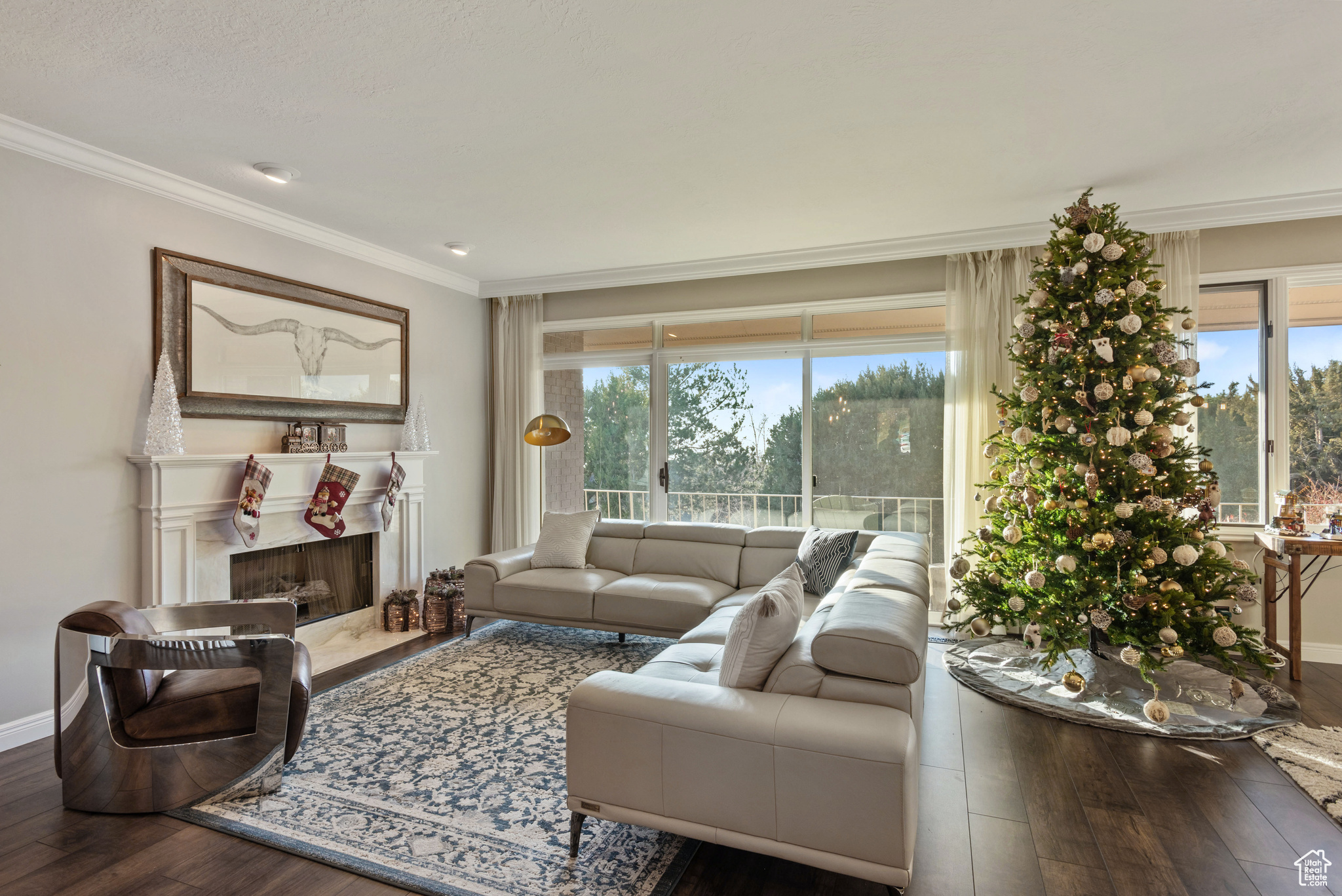 Living room featuring a fireplace, hardwood / wood-style flooring, a wealth of natural light, and crown molding