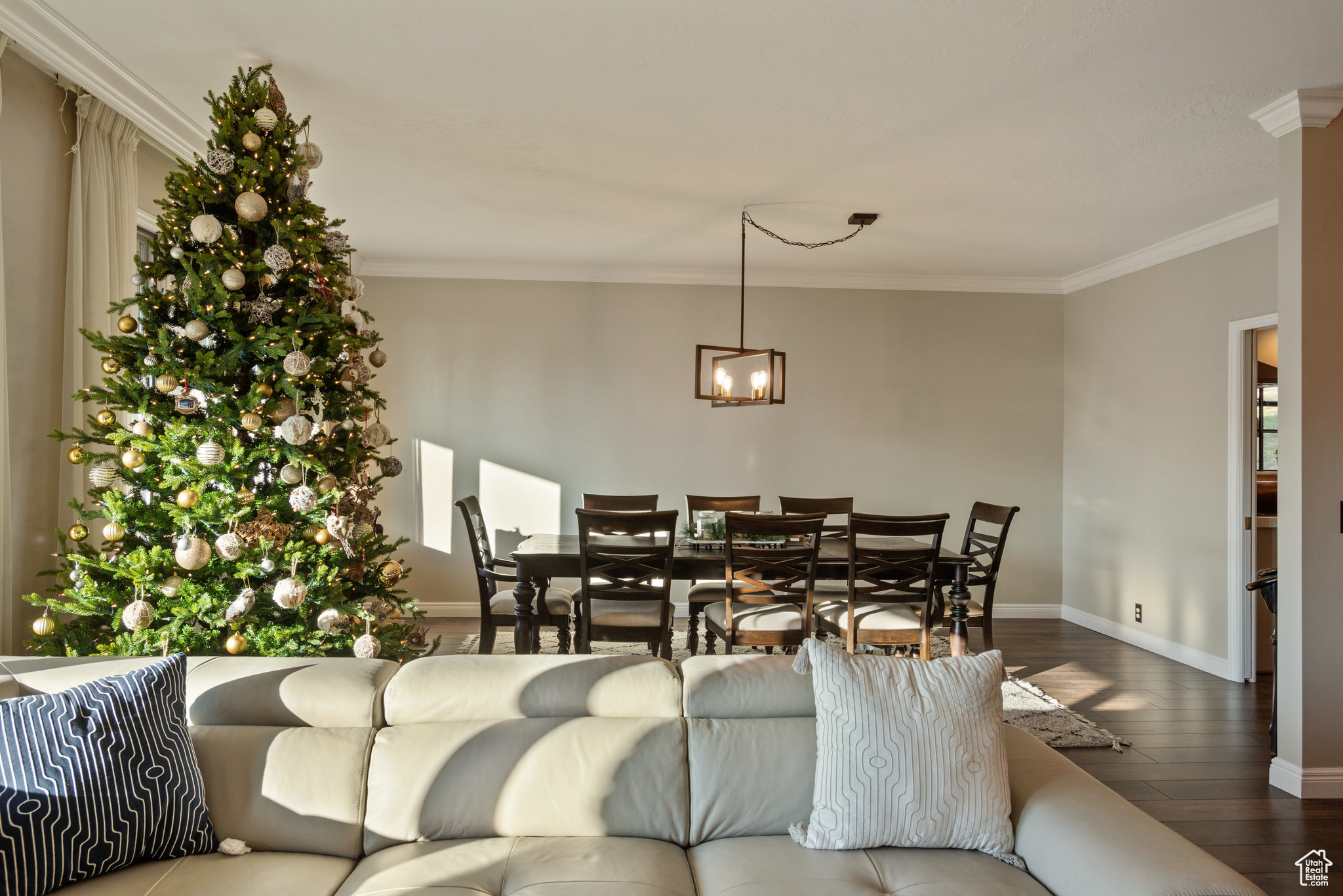 Living room featuring hardwood / wood-style floors, ornamental molding, and an inviting chandelier