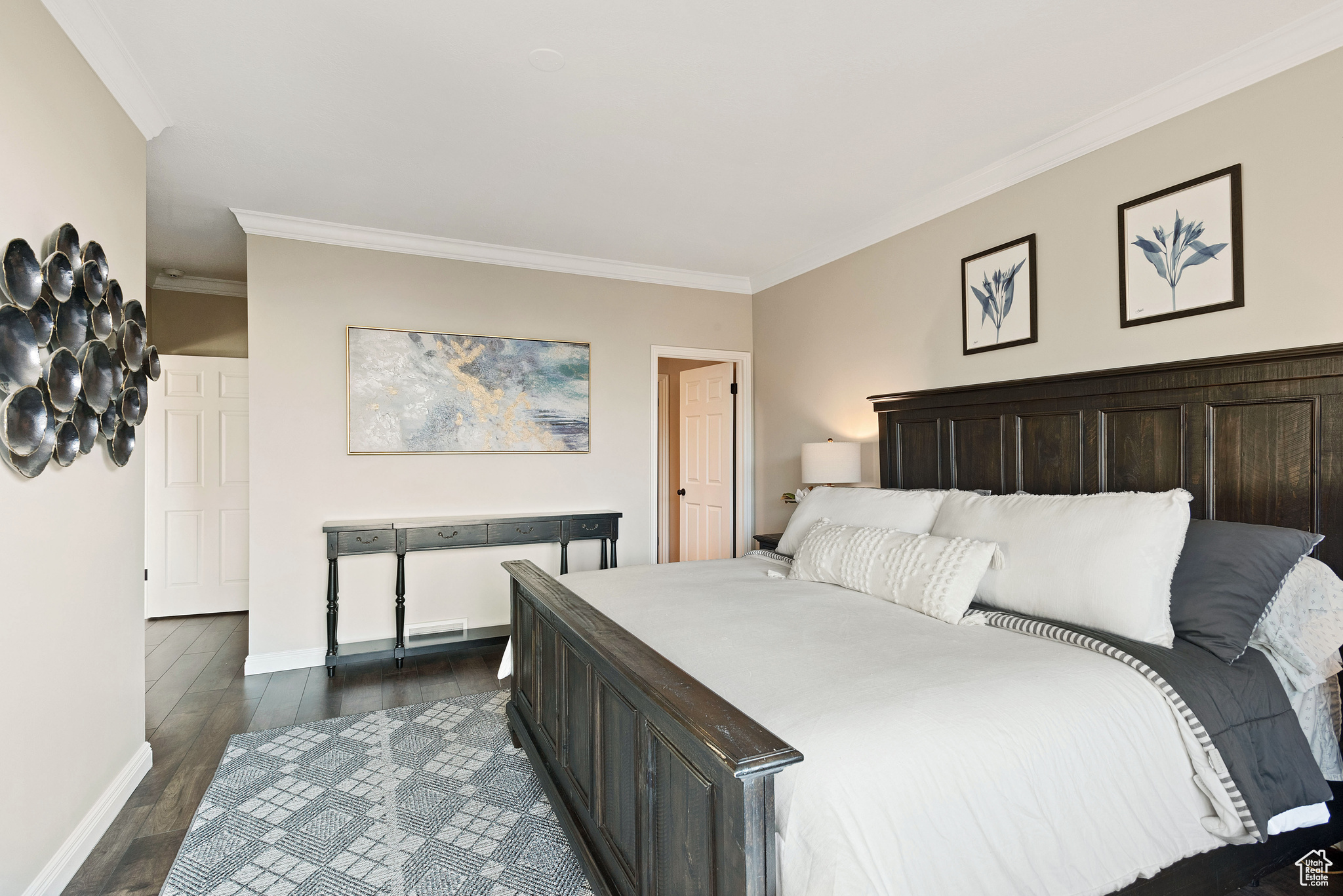 Bedroom featuring crown molding and dark wood-type flooring