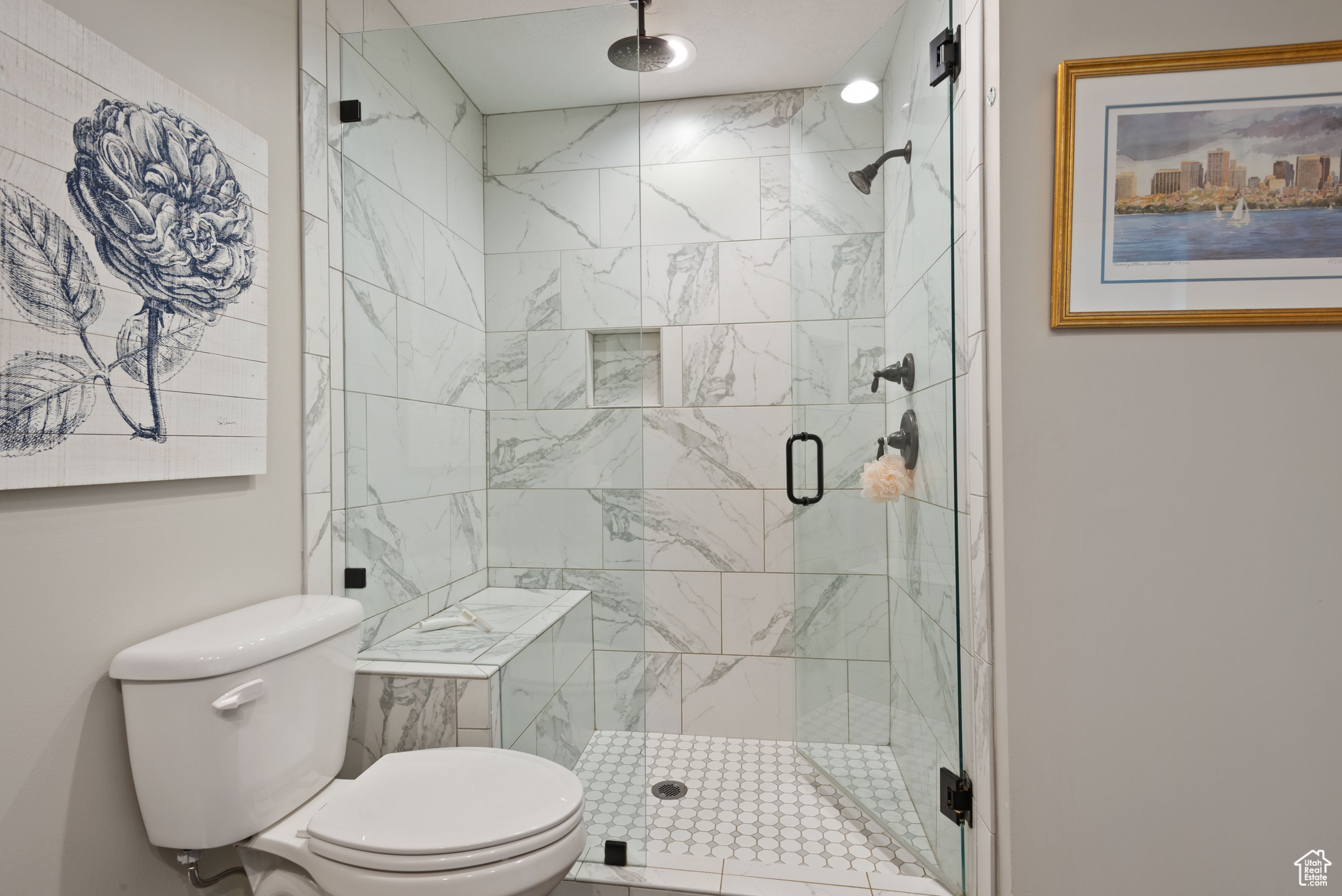 Bathroom featuring toilet and a shower with shower door