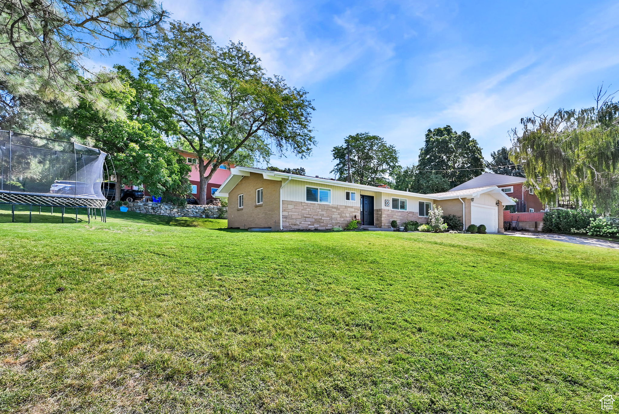 View of yard featuring a garage and a trampoline