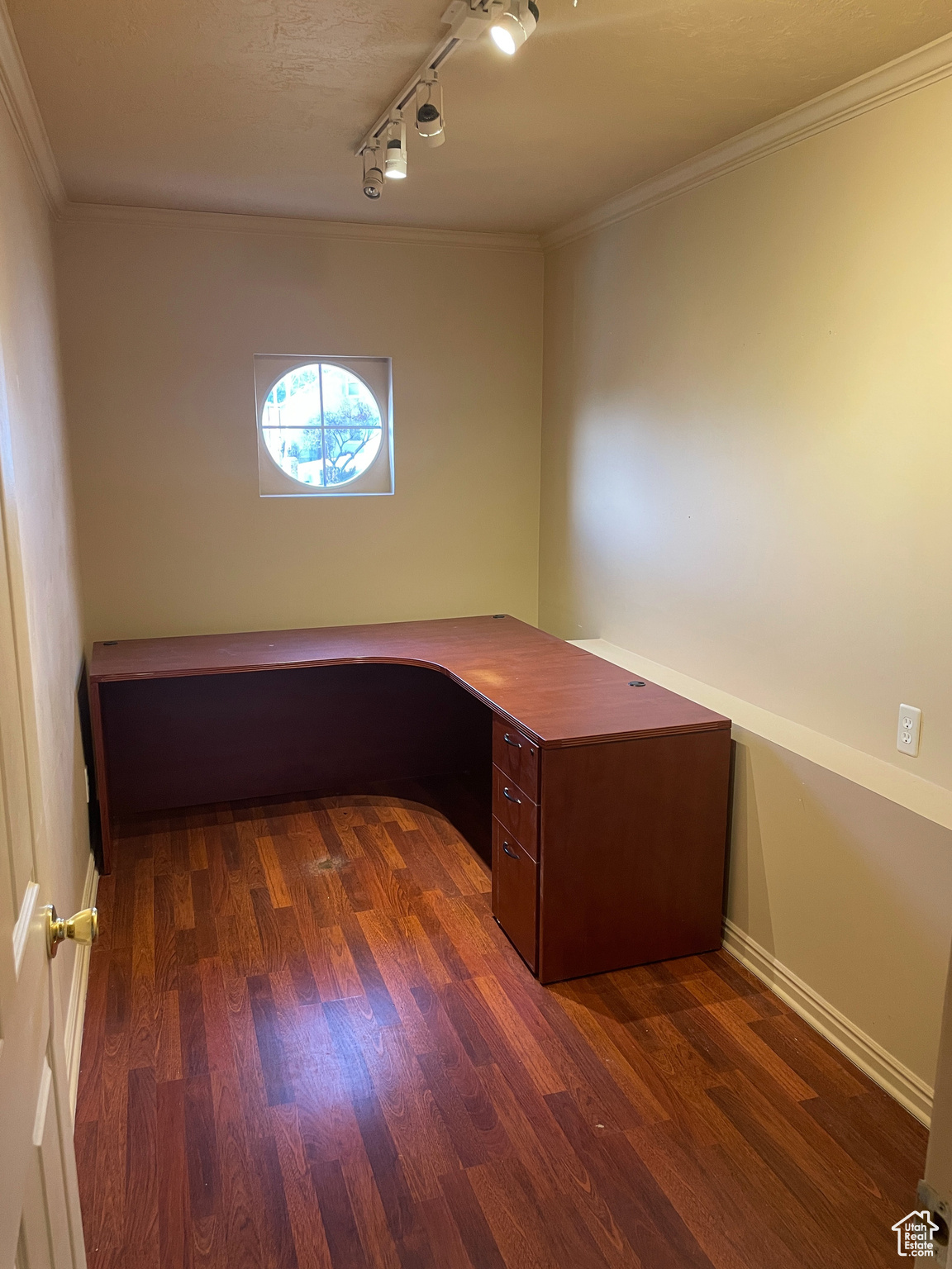 Unfurnished office with a textured ceiling, dark wood-type flooring, crown molding, and rail lighting