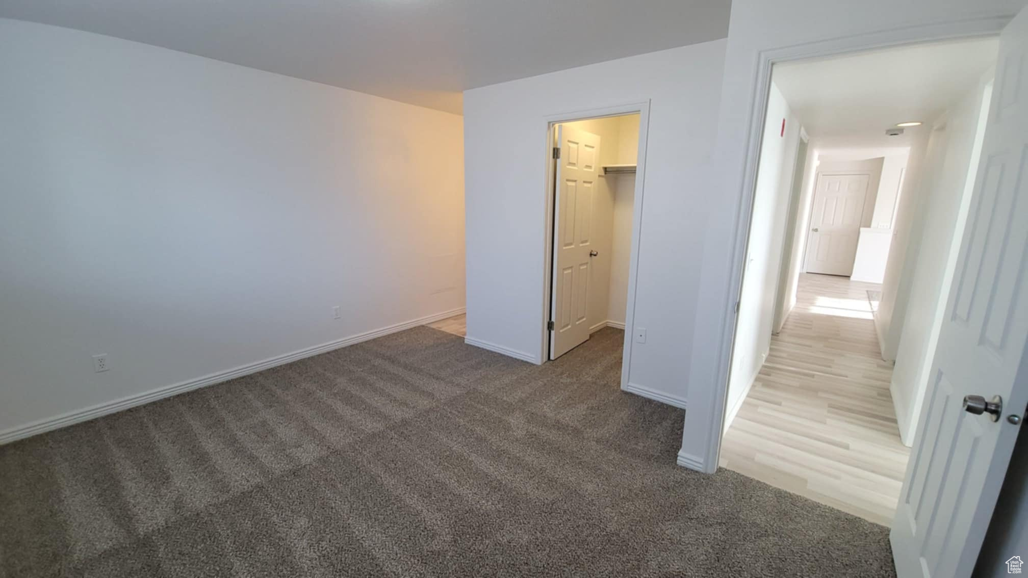 Unfurnished bedroom with a spacious closet, carpet floors, and a closet