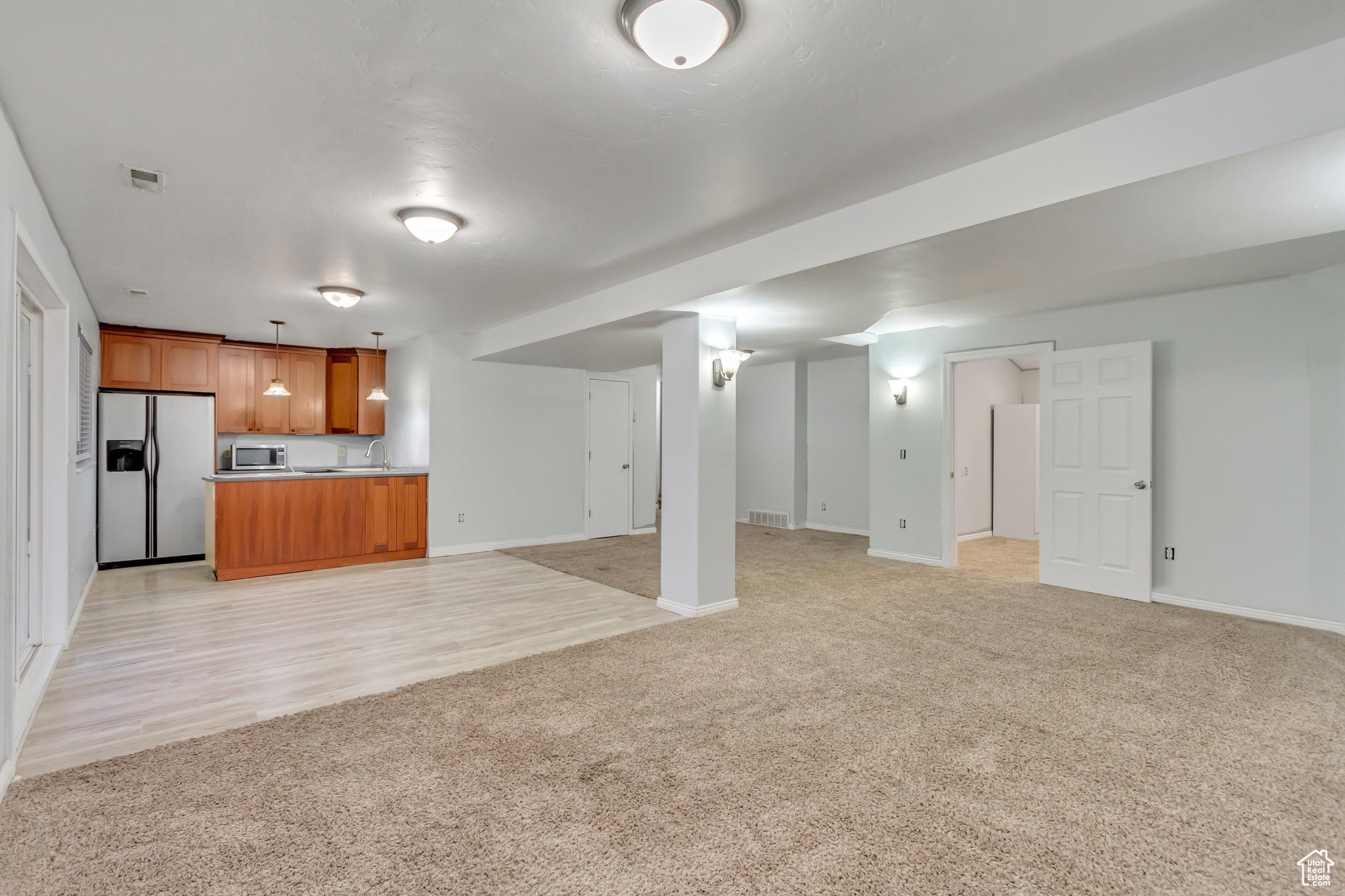 Interior space featuring pendant lighting, sink, light wood-type flooring, and stainless steel appliances