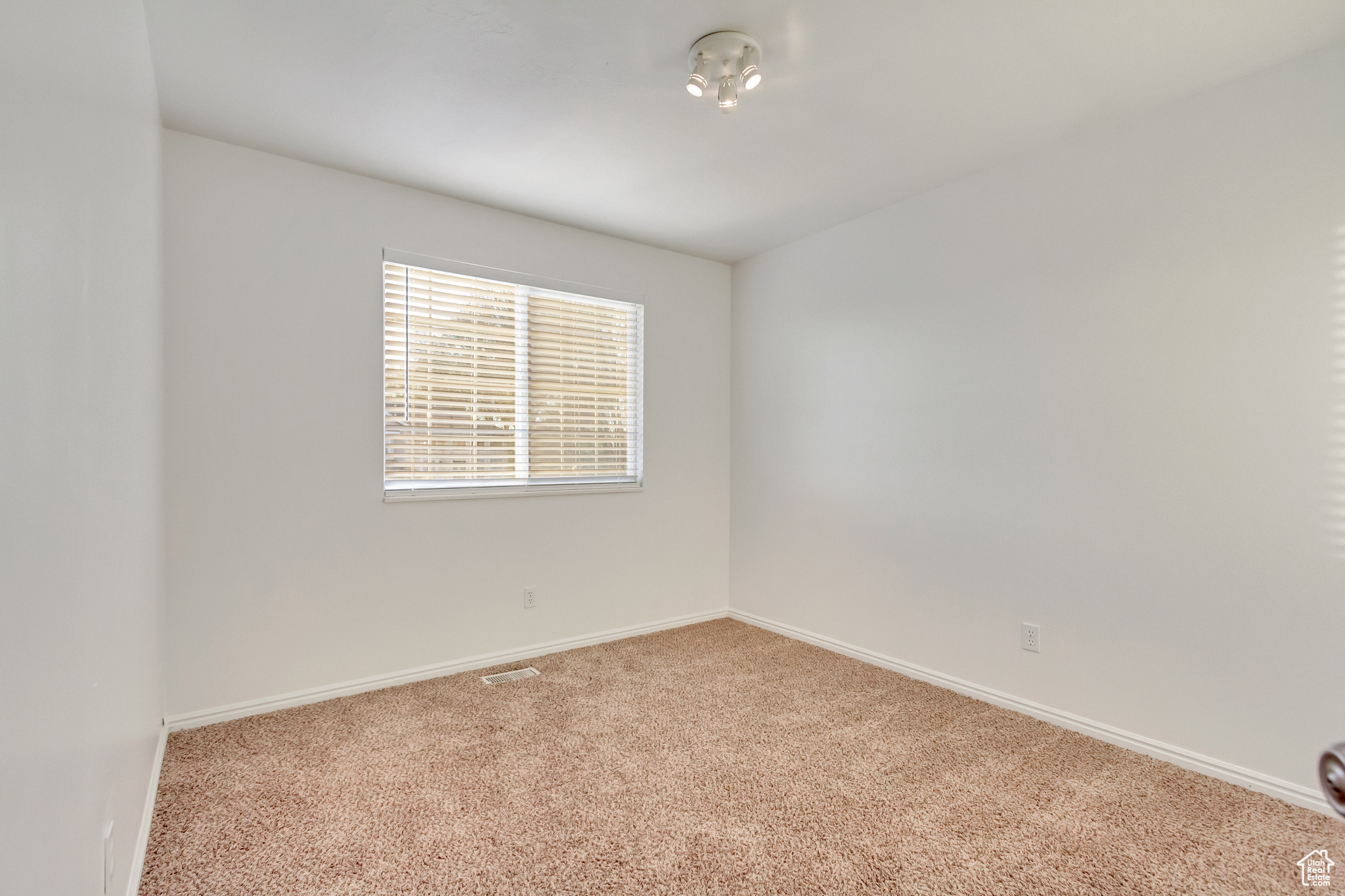 Empty room featuring light carpet