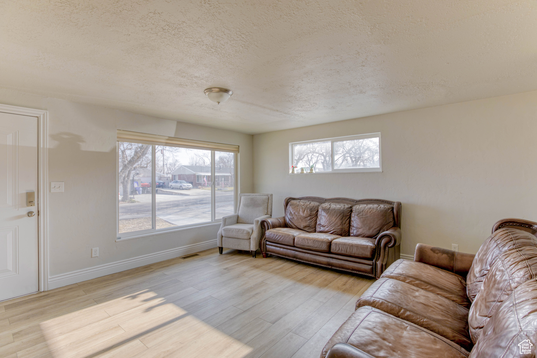 Living room featuring light hardwood / wood-style floors and a textured ceiling