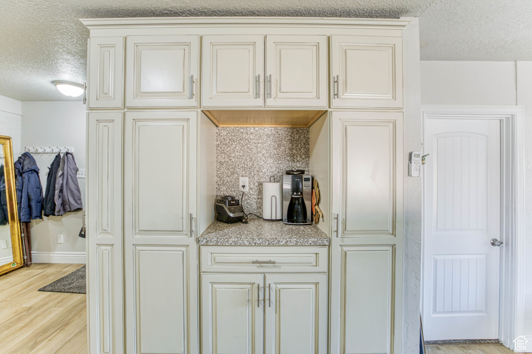 Kitchen with light hardwood / wood-style flooring and a textured ceiling