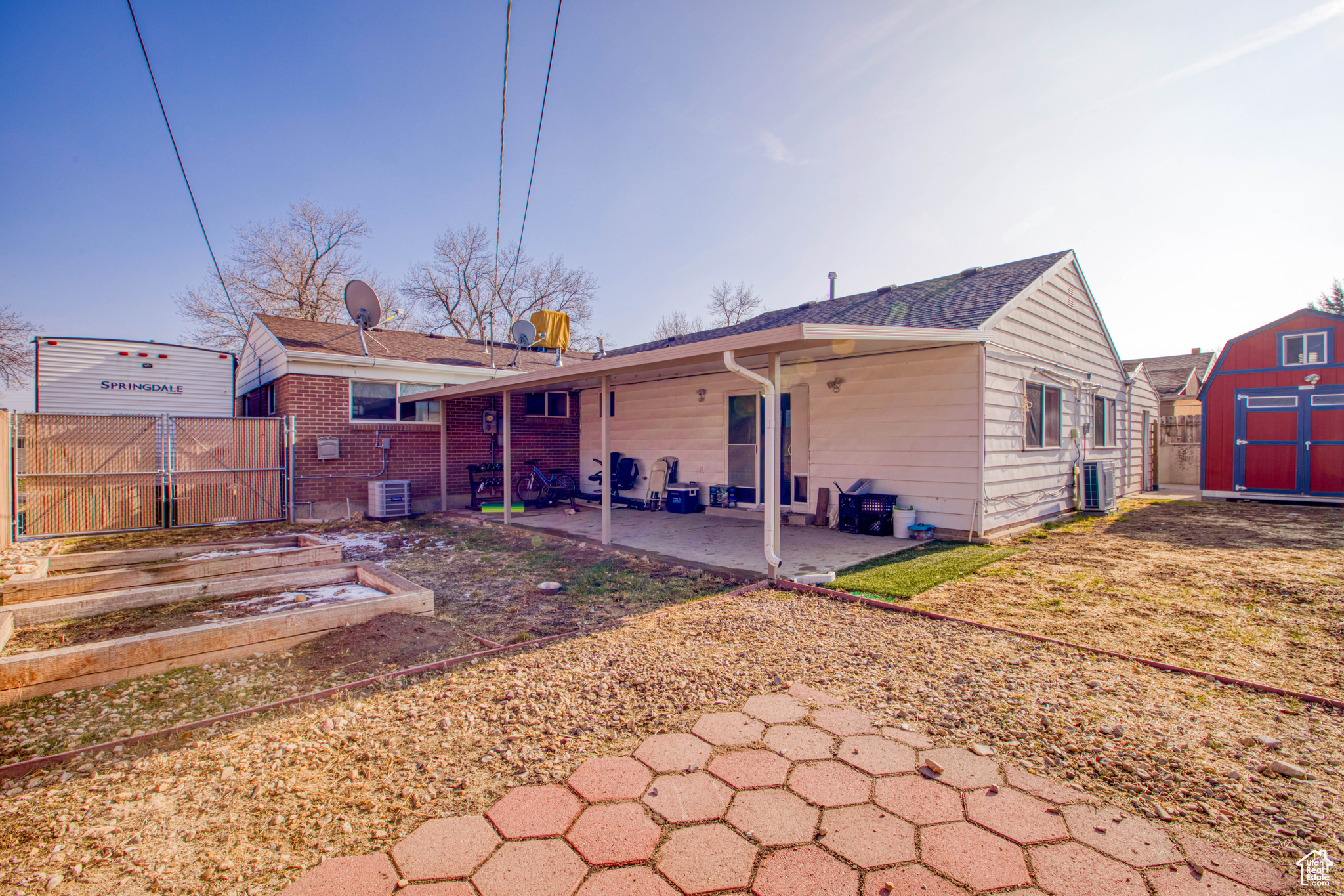 Rear view of property featuring a patio area, cooling unit, and a storage shed