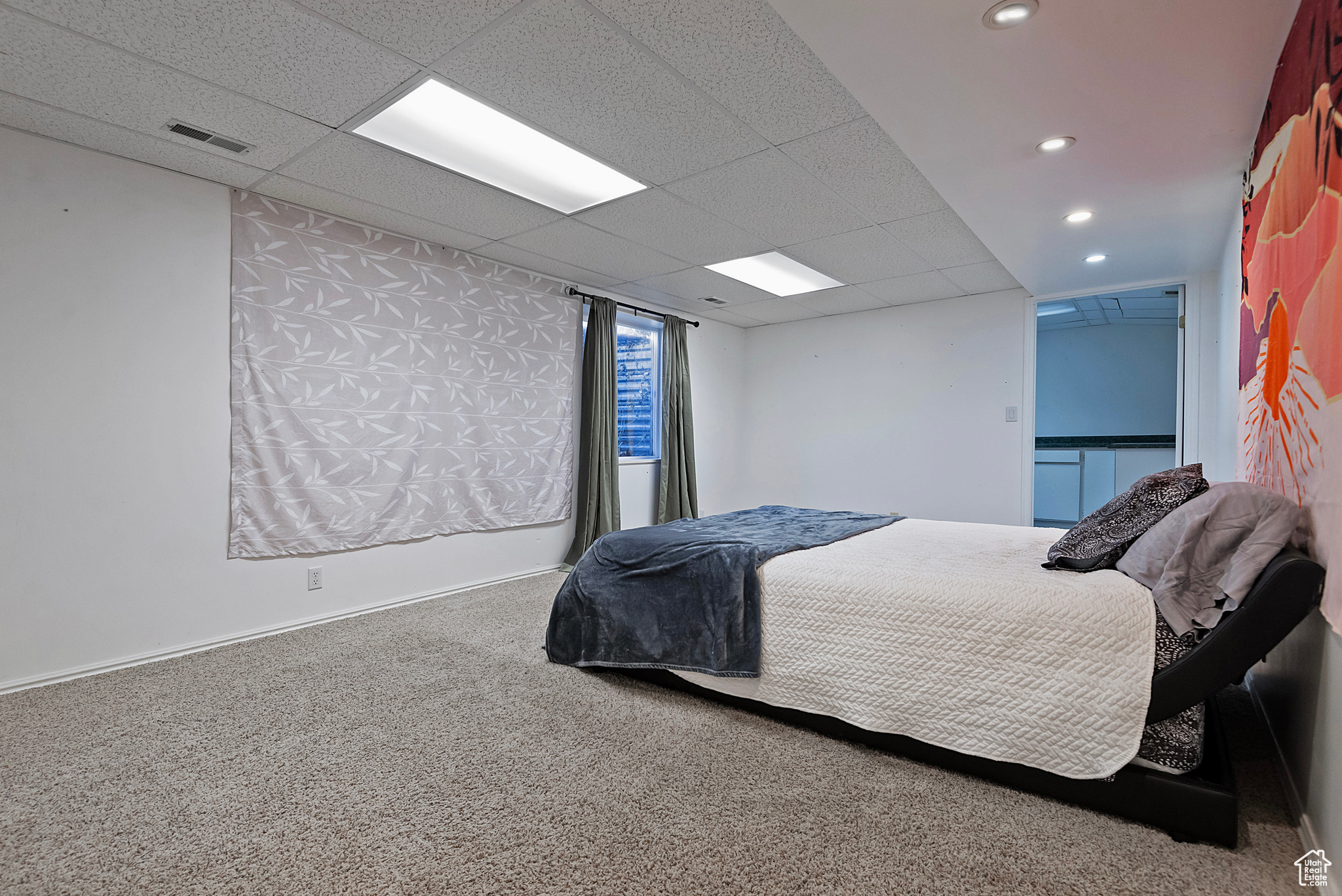 Carpeted bedroom featuring a drop ceiling