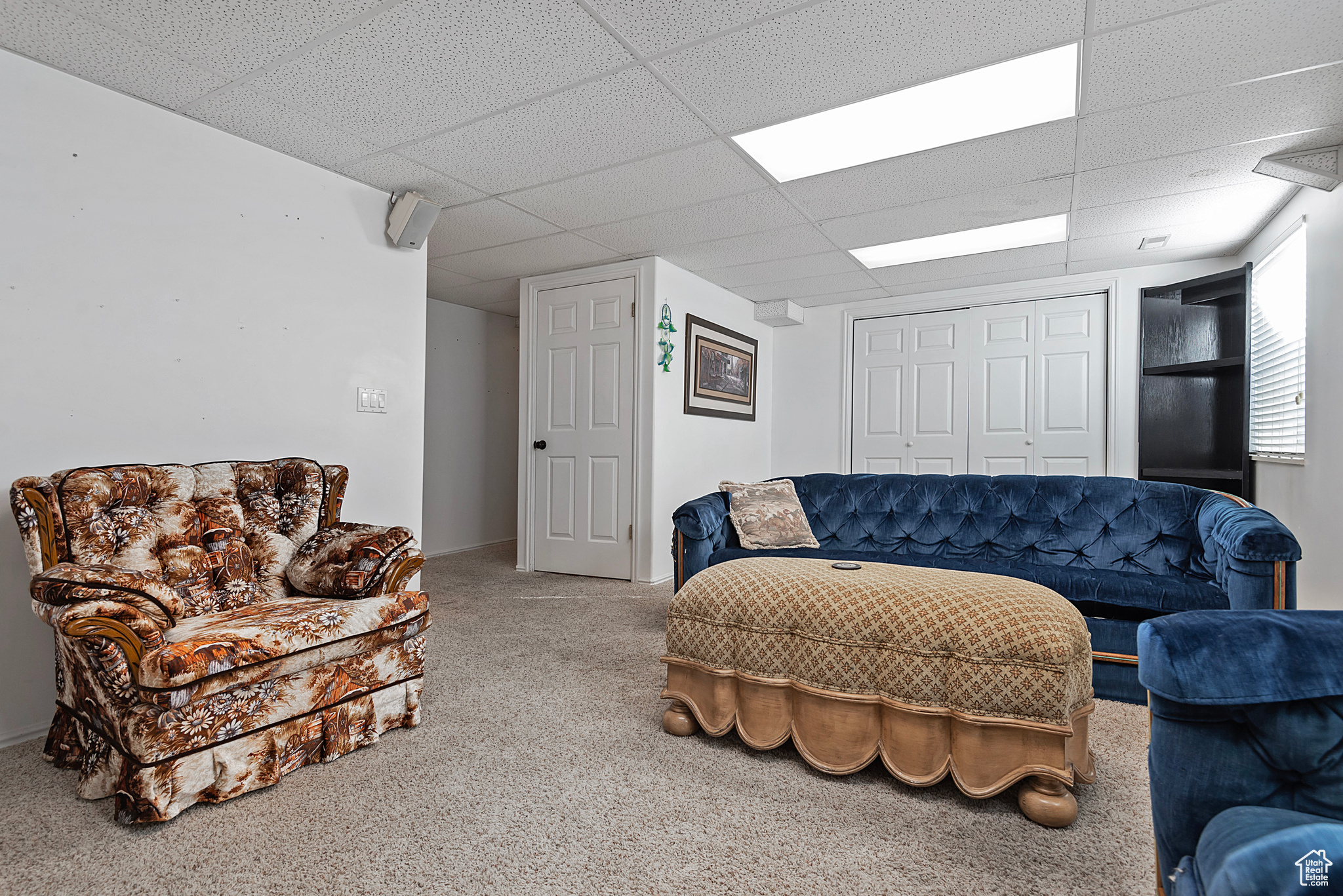 Living room with a paneled ceiling and carpet floors