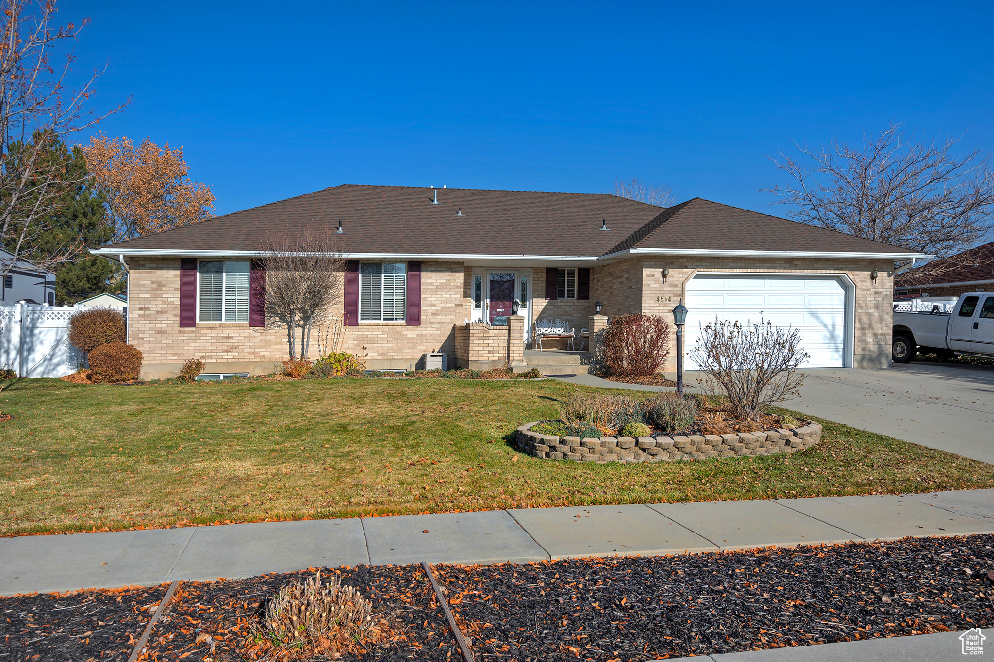 Ranch-style home featuring a front lawn and a garage