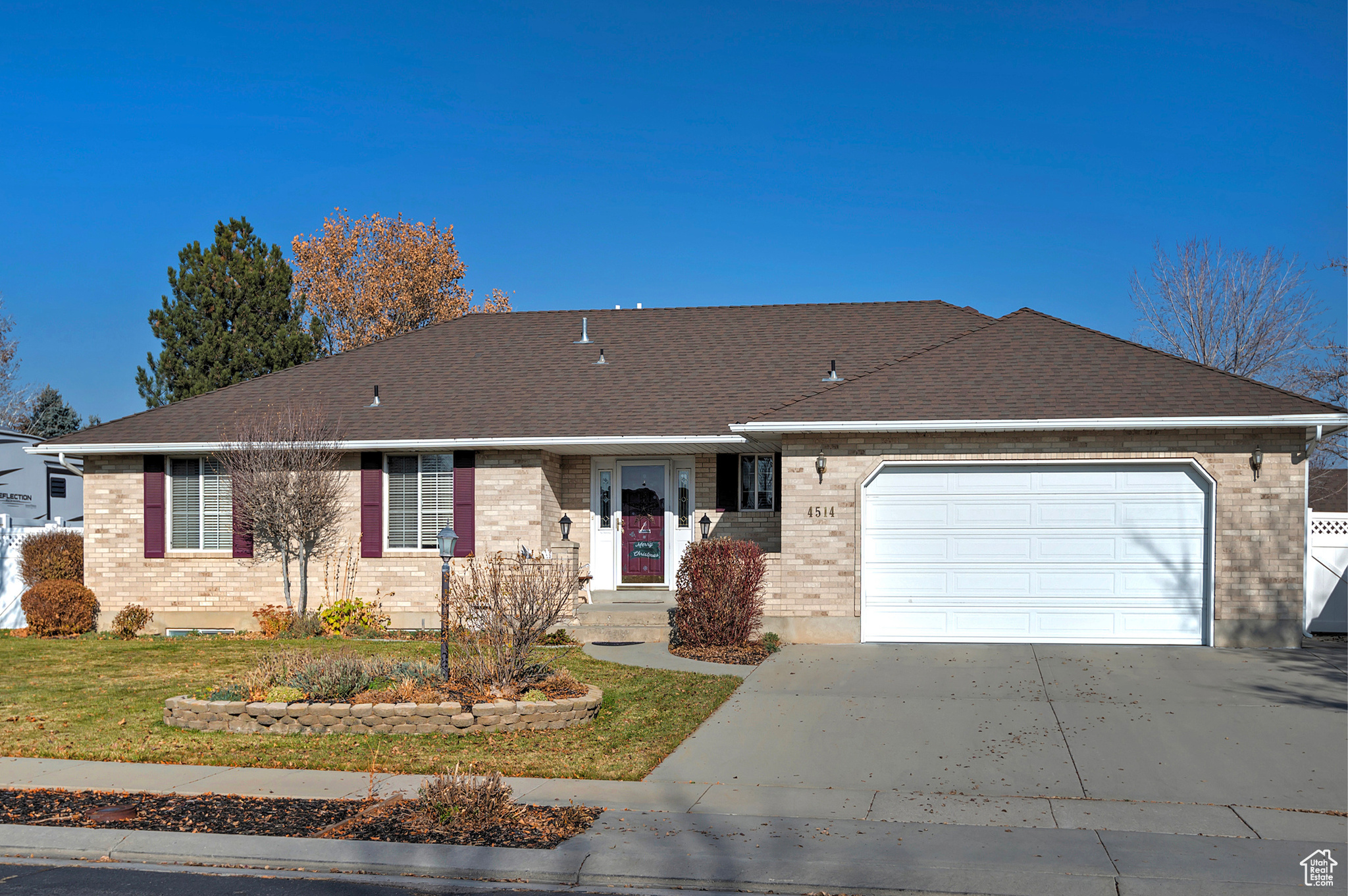 Ranch-style house featuring a garage and a front lawn