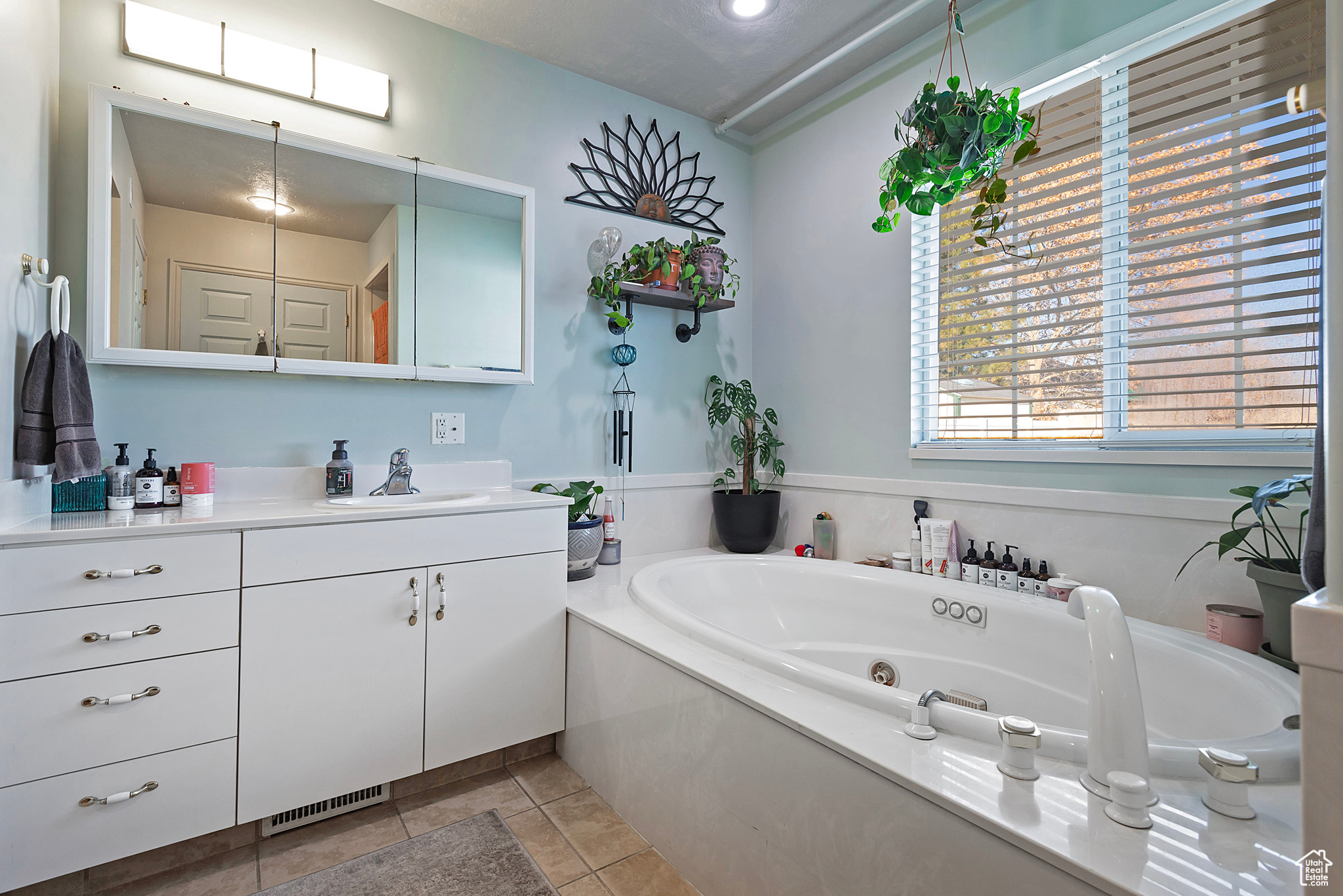 Bathroom with tile patterned flooring, vanity, and a tub