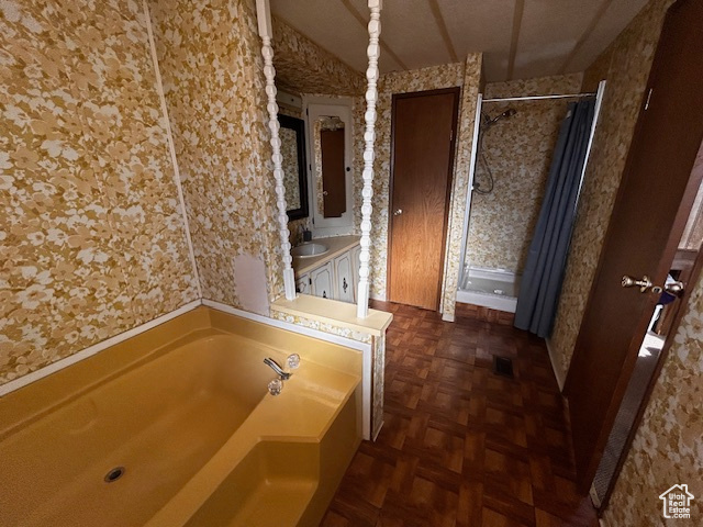 Bathroom featuring shower with separate bathtub, parquet floors, and sink