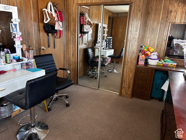 Carpeted home office with wood walls