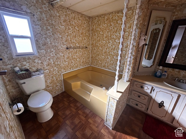 Bathroom with a bathing tub, toilet, vanity, and parquet flooring