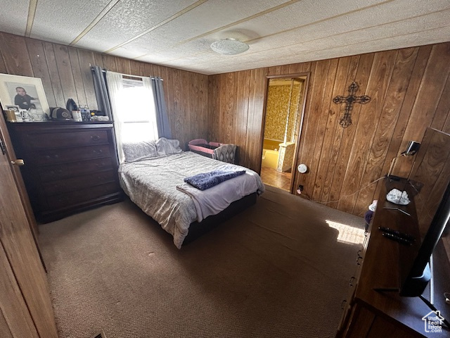 Bedroom featuring carpet and wooden walls