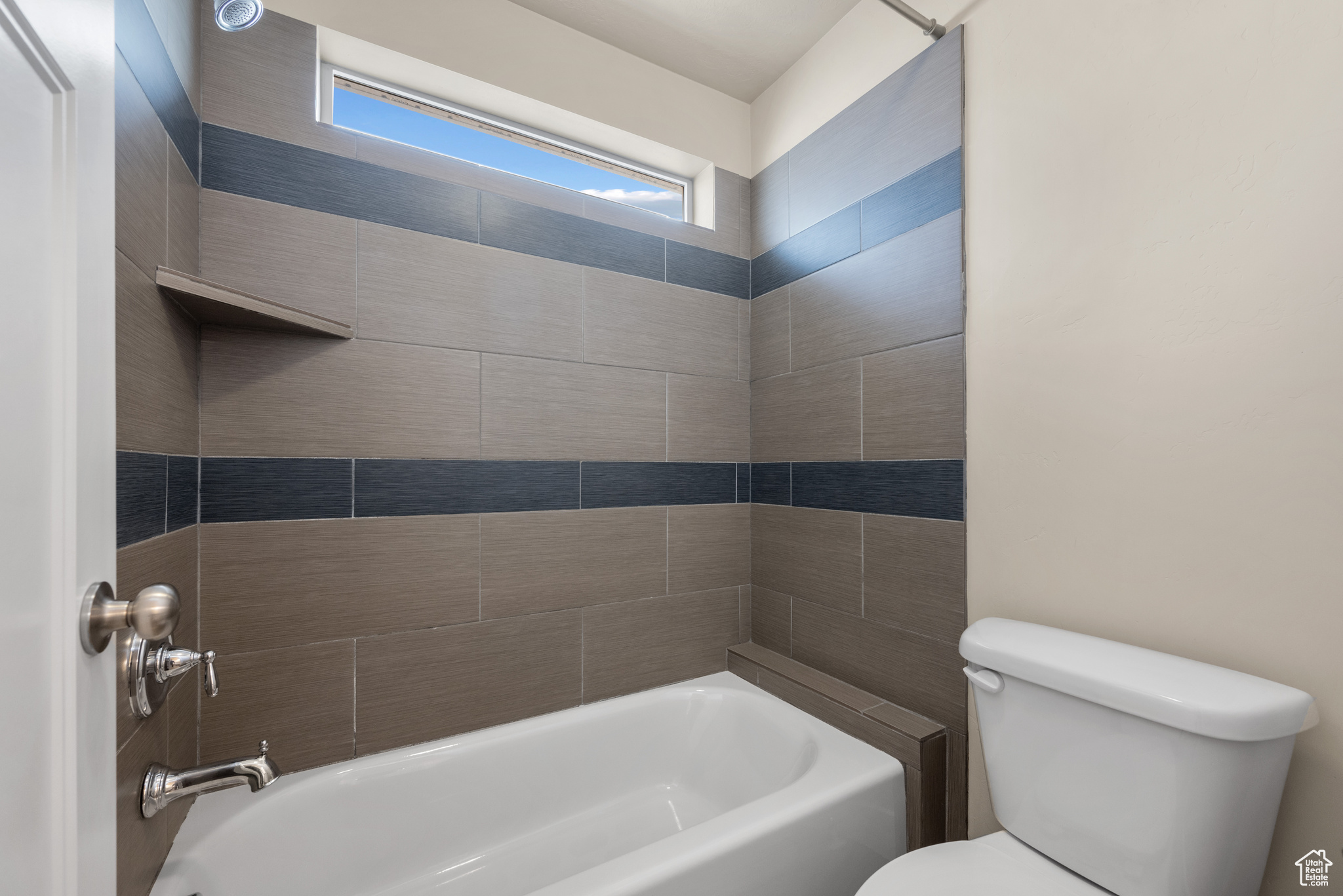 Bathroom featuring shower / washtub combination and toilet