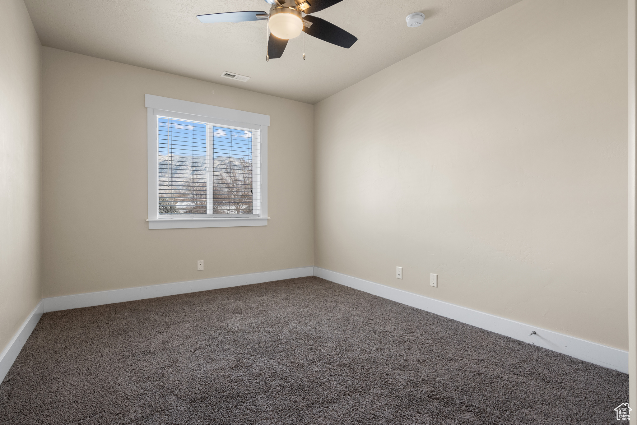 Carpeted empty room with ceiling fan