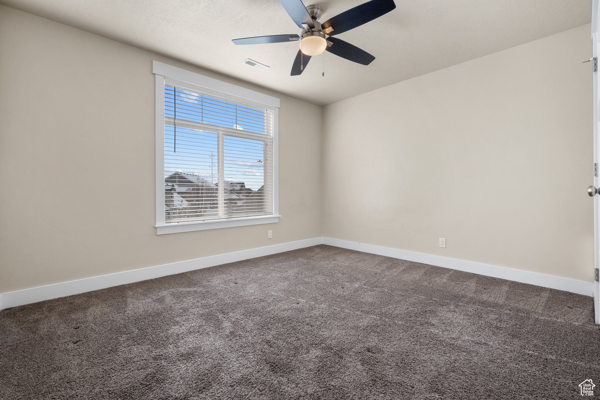 Spare room with ceiling fan and carpet flooring