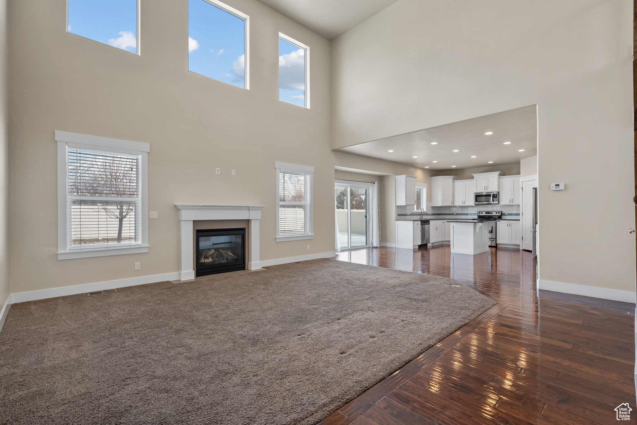 Unfurnished living room with a healthy amount of sunlight and a towering ceiling