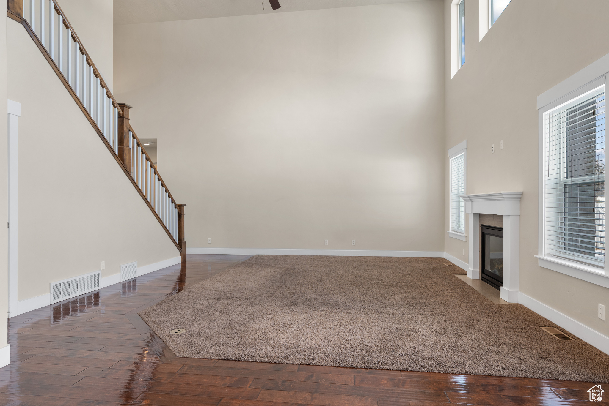 Unfurnished living room with dark wood-type flooring and a high ceiling