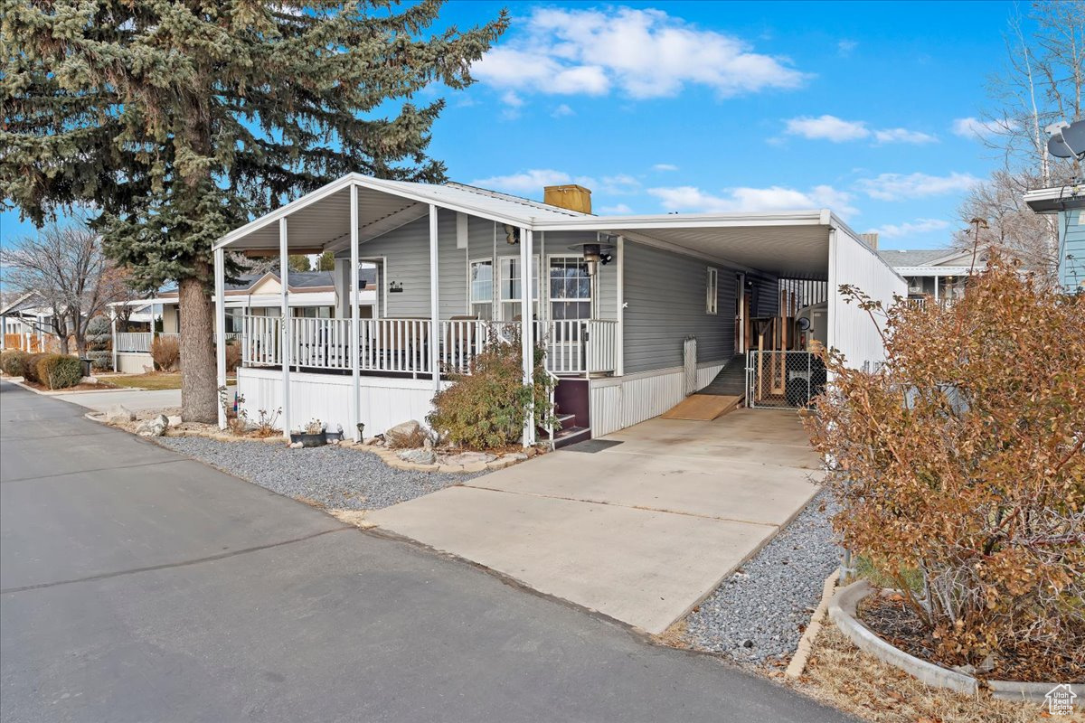 Manufactured / mobile home featuring a carport and a porch