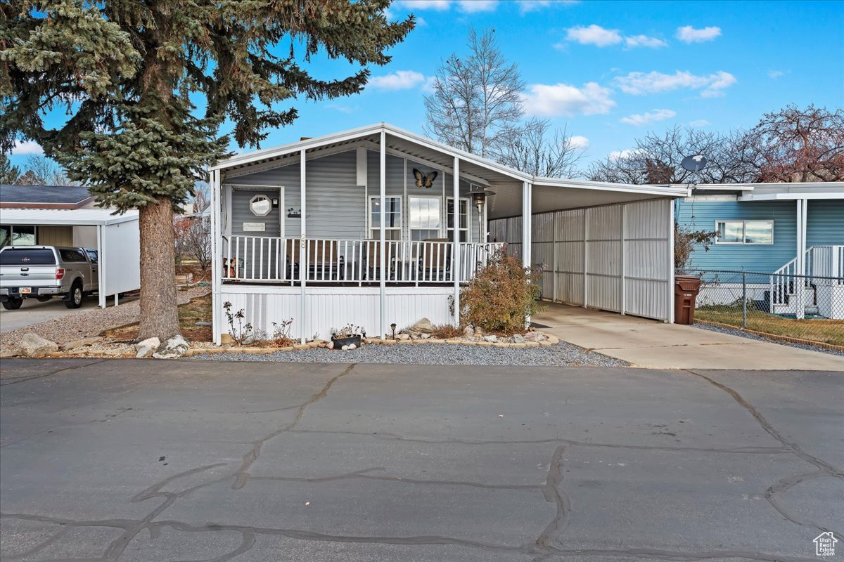 Manufactured / mobile home featuring a carport and a porch