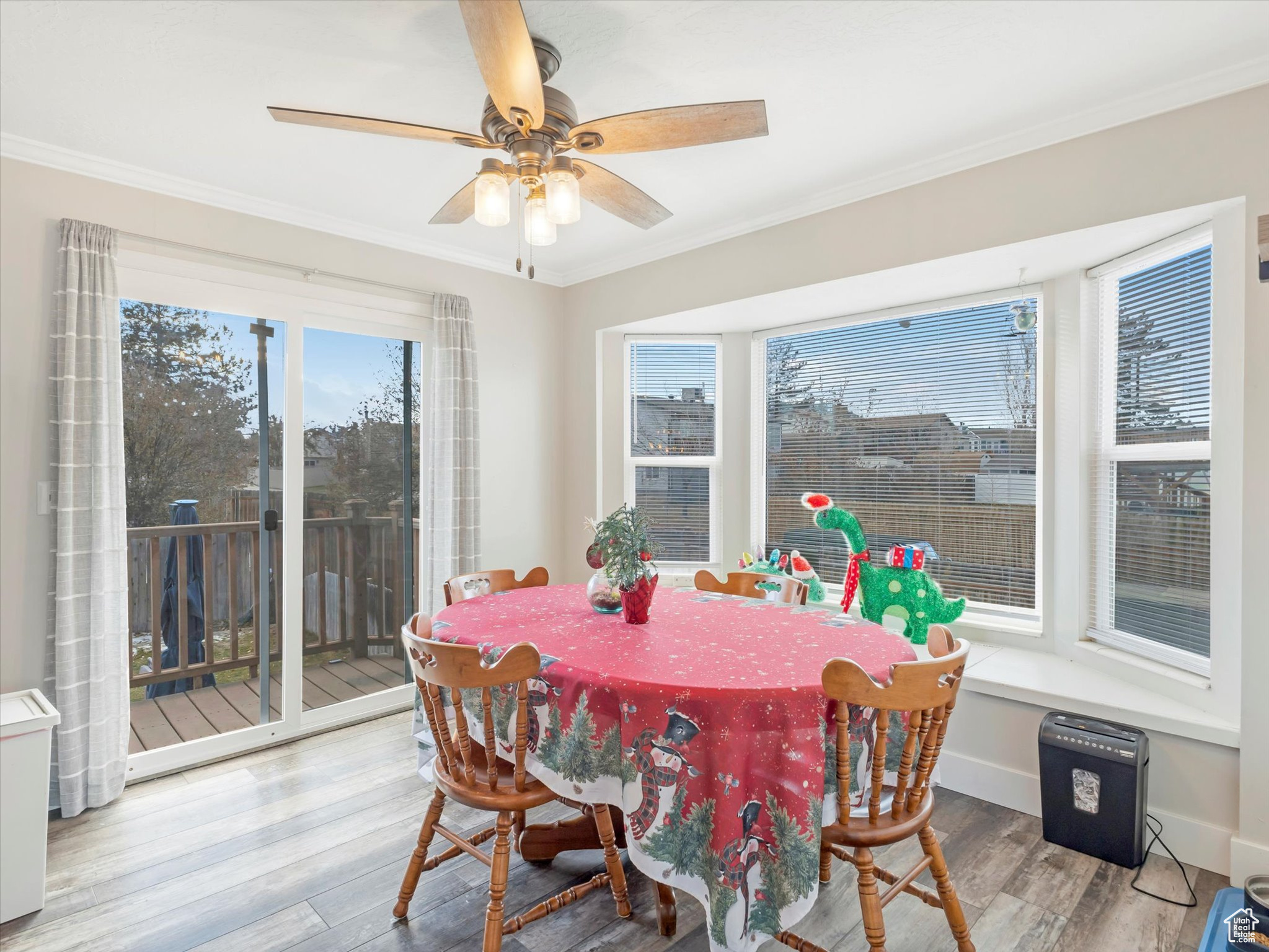 Dining area featuring hardwood / wood-style floors, ceiling fan, and crown molding