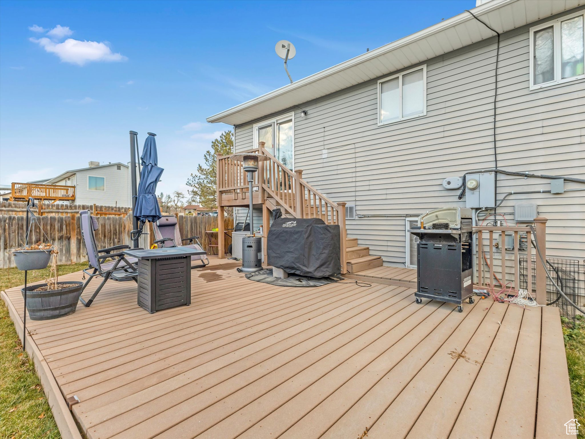 Wooden terrace featuring grilling area and an outdoor fire pit