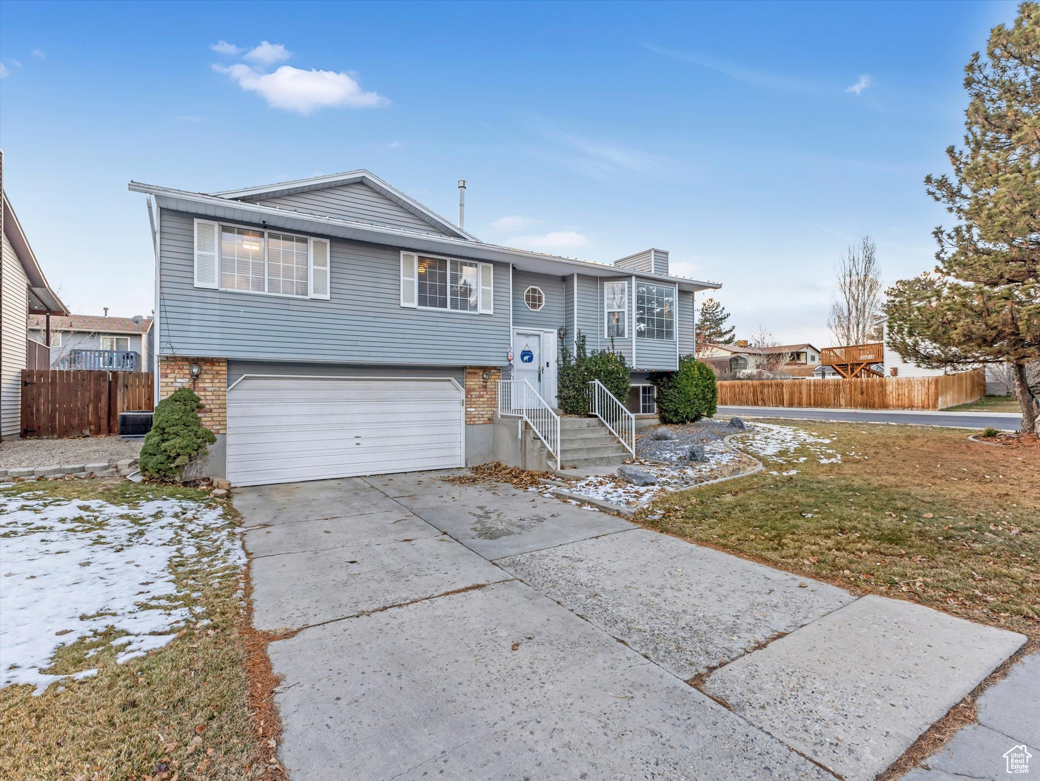 Bi-level home featuring a garage and a front lawn