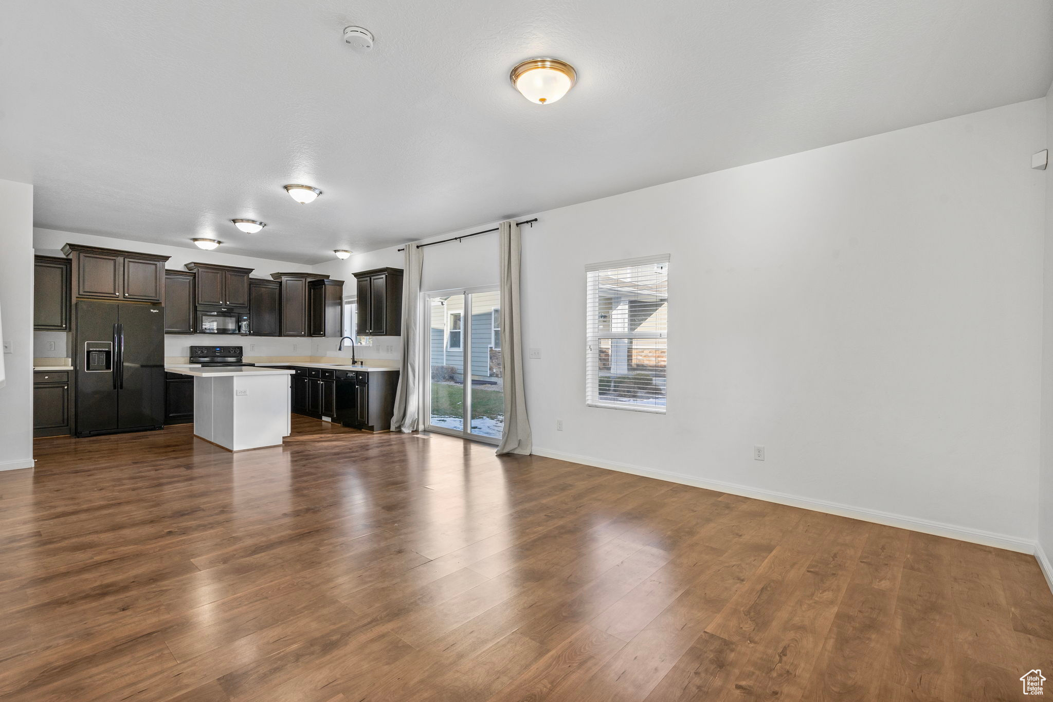 Unfurnished living room with dark hardwood / wood-style flooring and sink