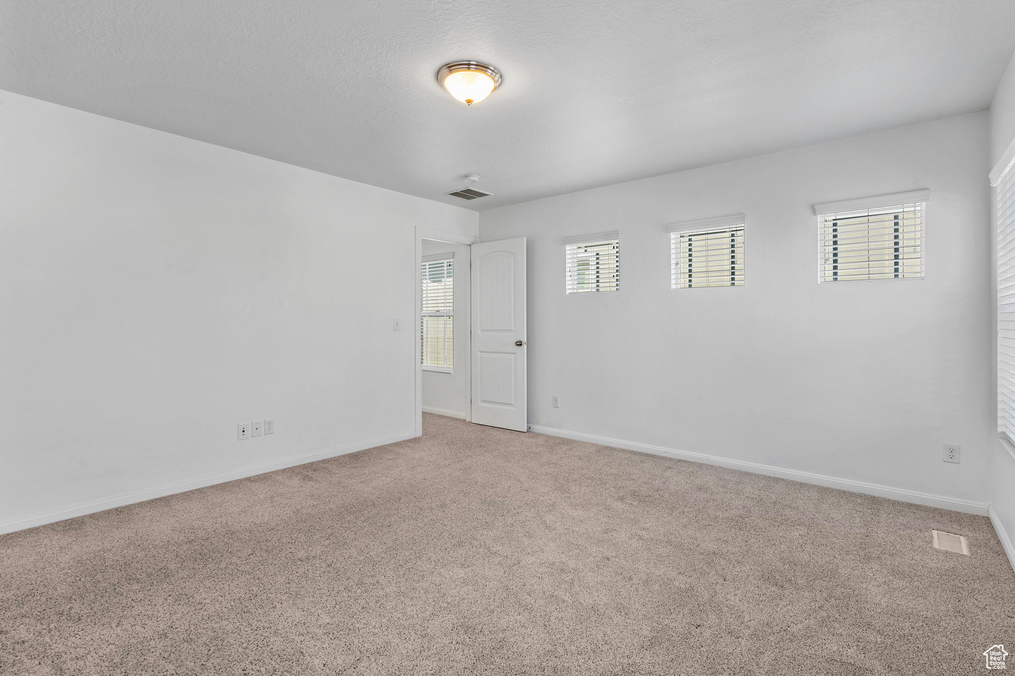 Spare room with plenty of natural light and carpet