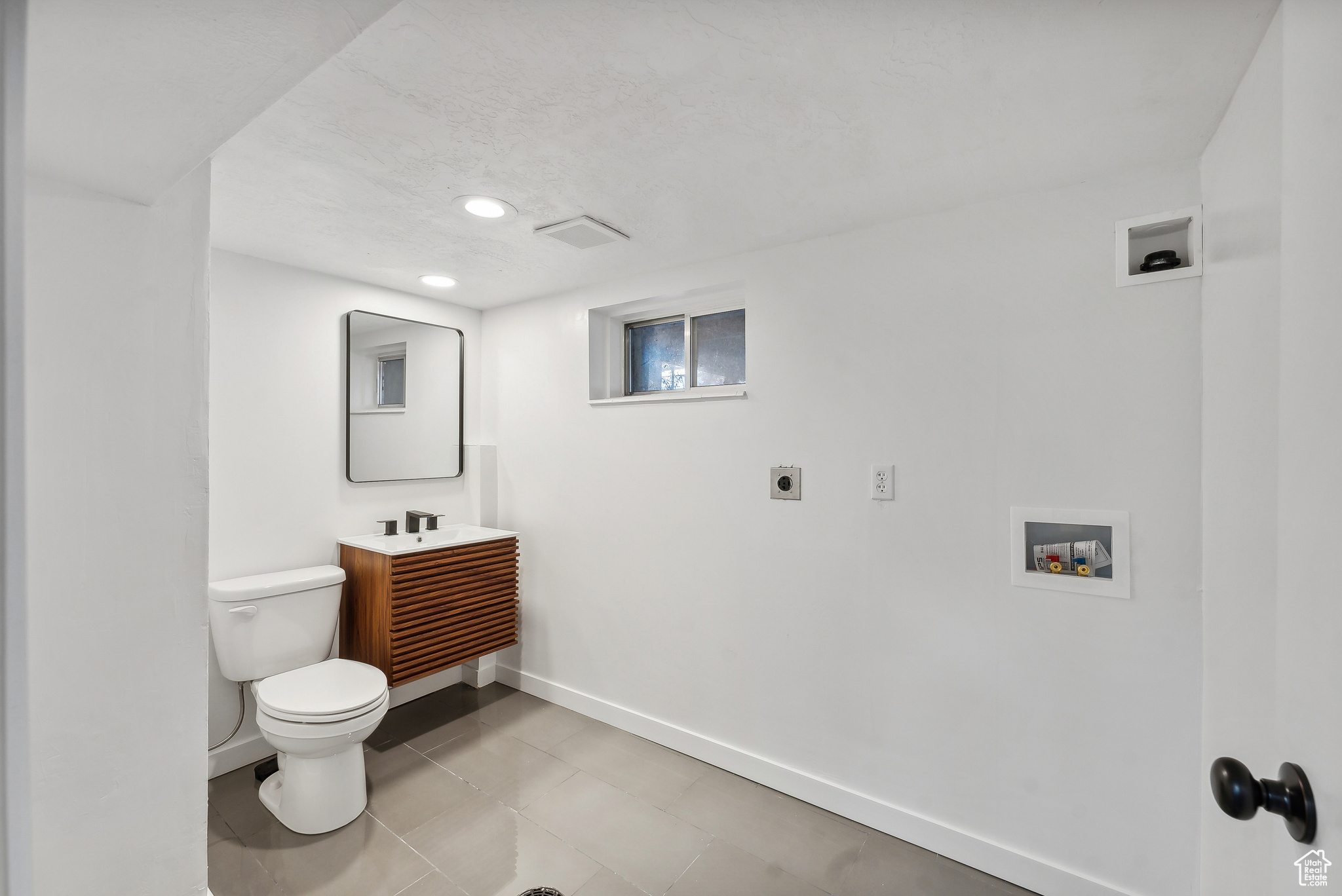 Bathroom featuring tile patterned floors, vanity, and toilet