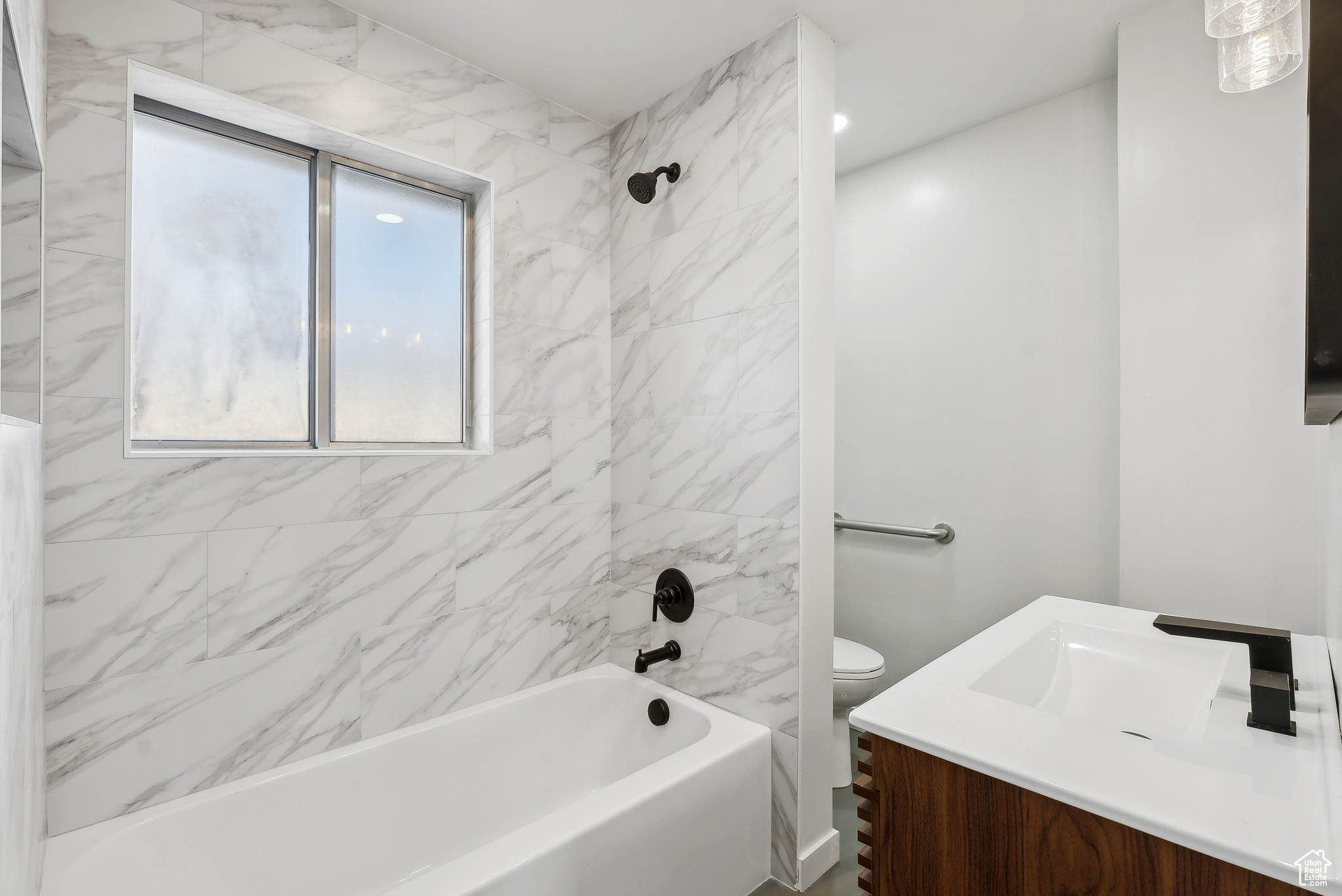 Full bathroom featuring vanity, toilet, and tiled shower / bath