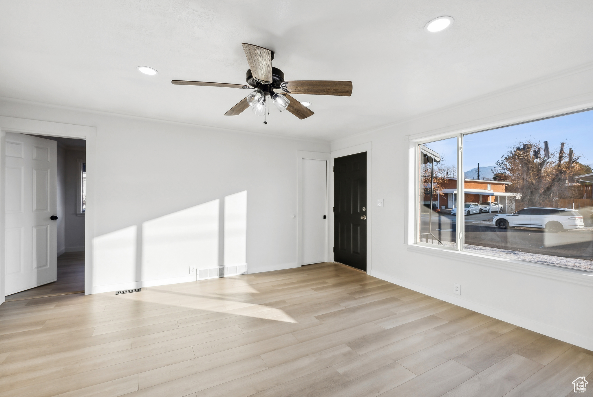 Unfurnished room with ceiling fan, light hardwood / wood-style flooring, and ornamental molding