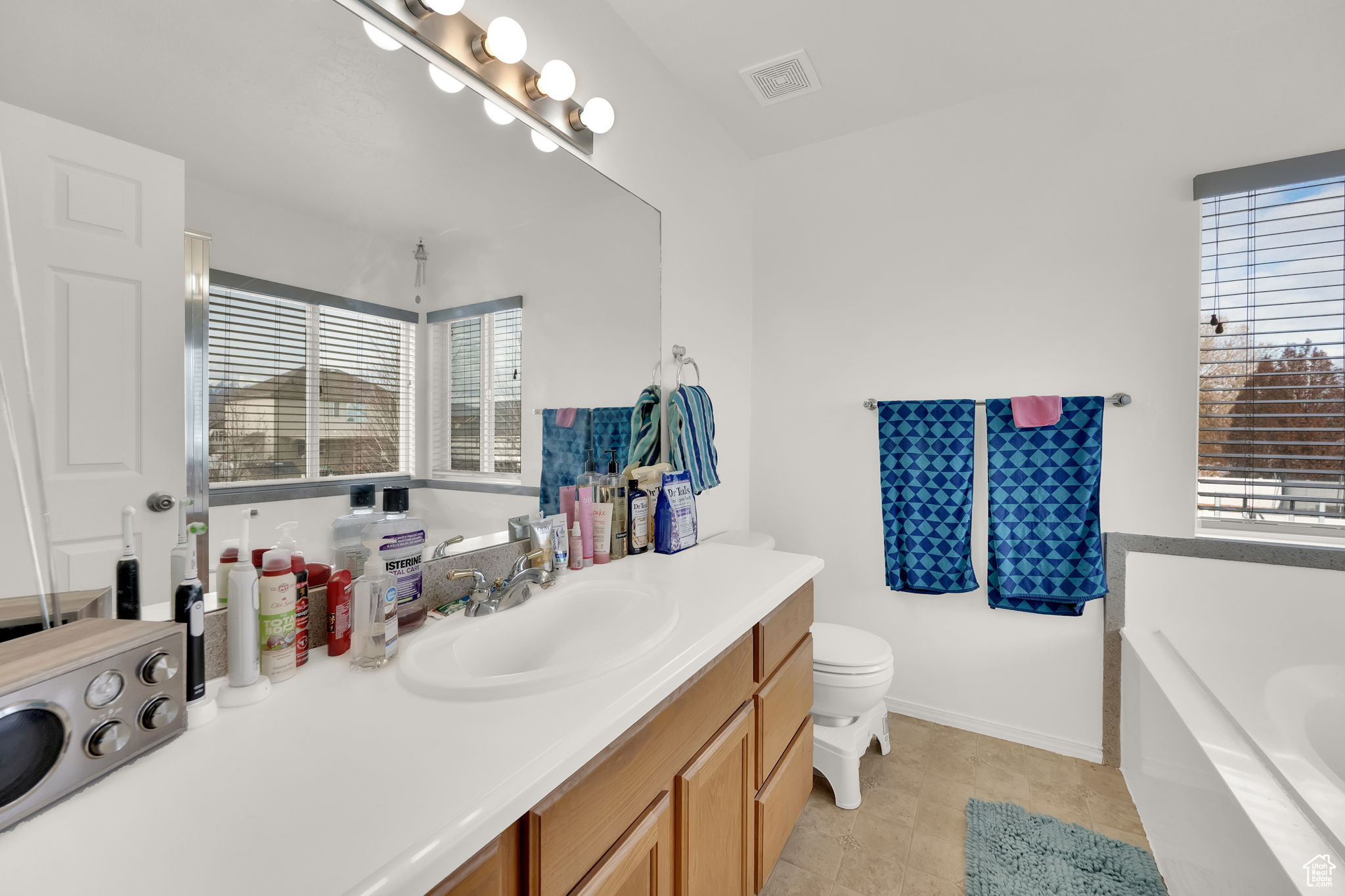 Bathroom with tile patterned flooring, vanity, a bathtub, and toilet