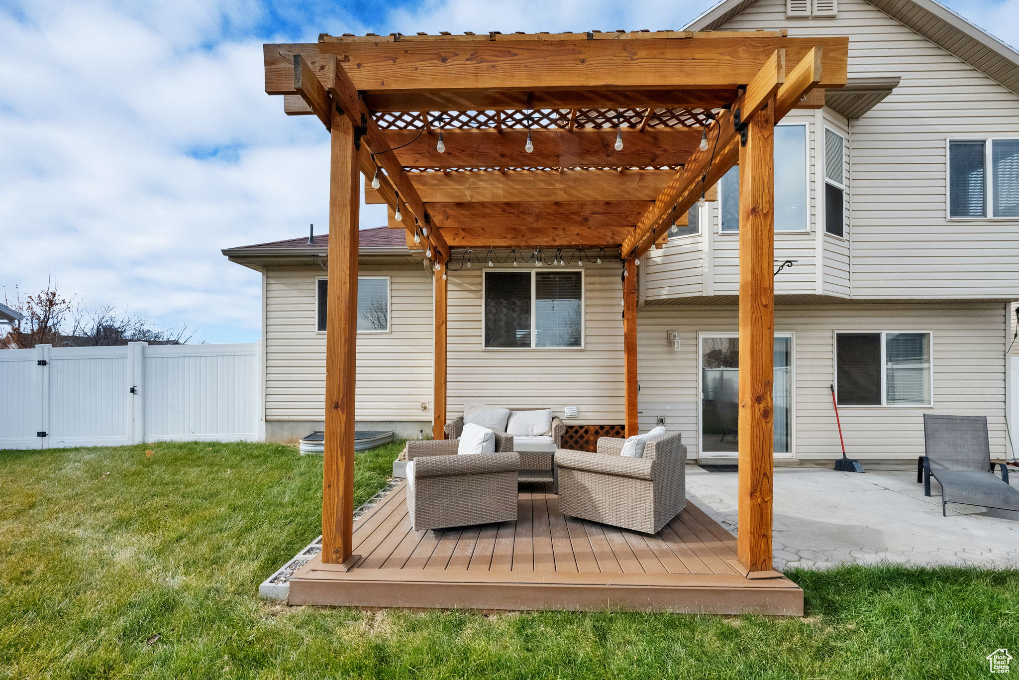 Rear view of property featuring a pergola, a wooden deck, outdoor lounge area, and a yard