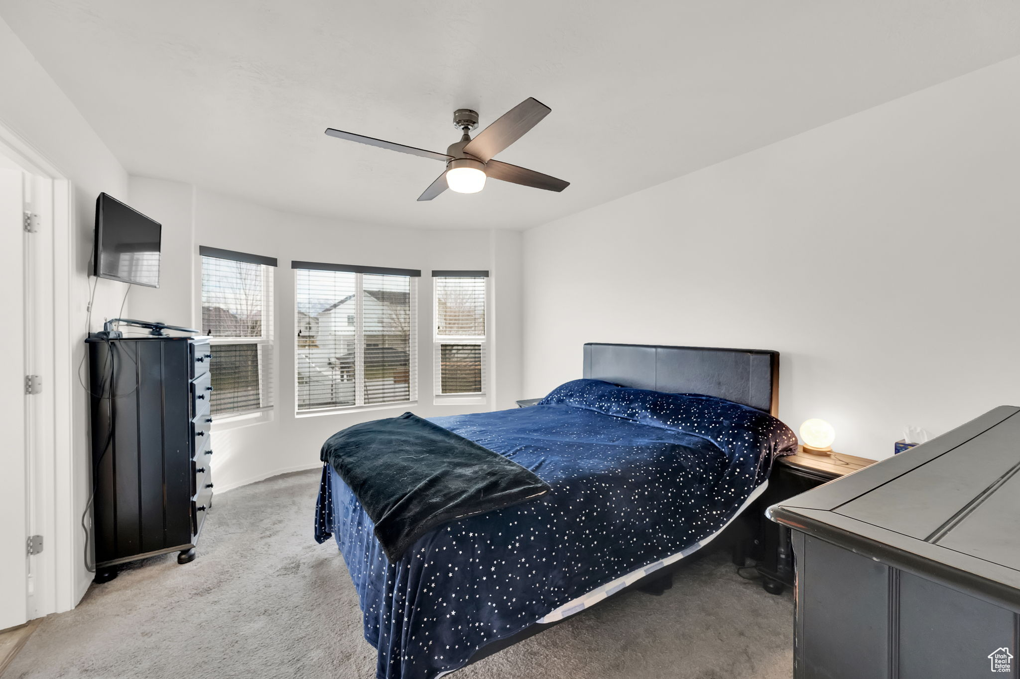 Carpeted bedroom featuring ceiling fan